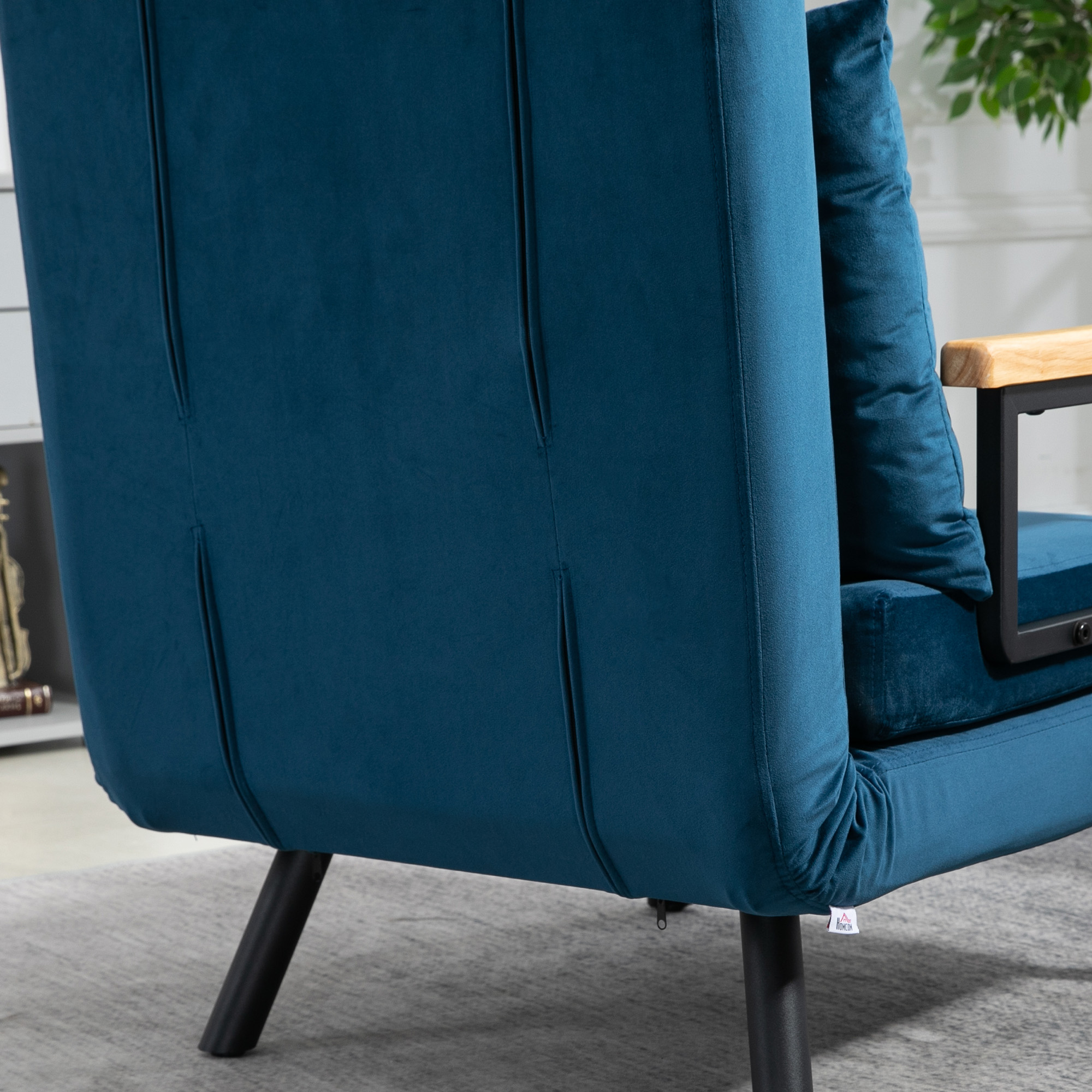 Un sofá de terciopelo azul es visible, con un reposabrazos de madera y un cojín.