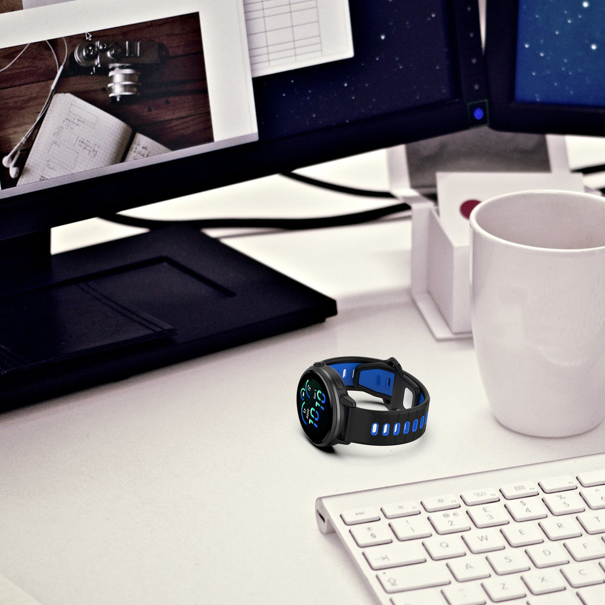 Eine Smartwatch mit schwarzem Band und blauen Akzenten liegt auf einem weißen Schreibtisch. Eine Tastatur ist sichtbar.