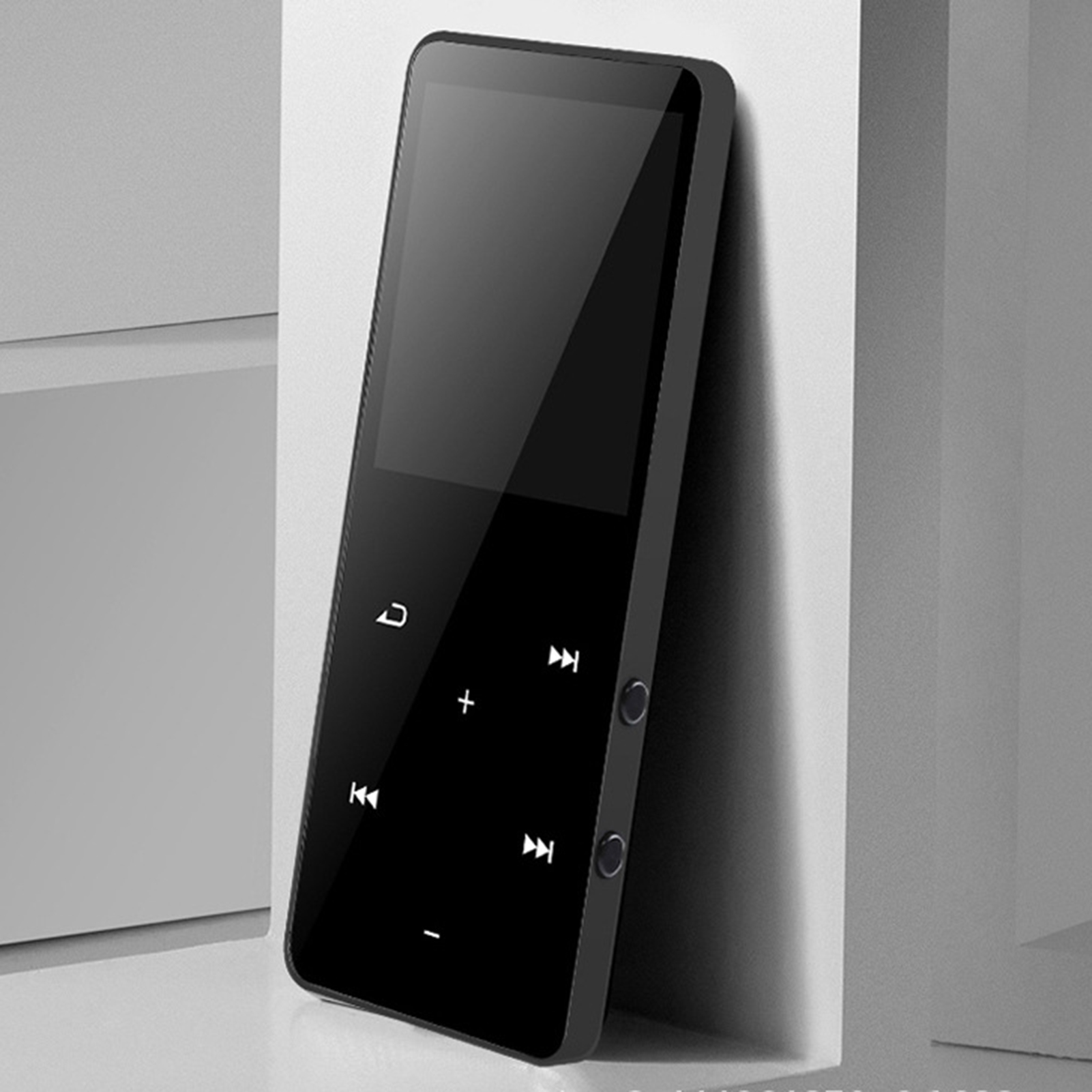 Ein schwarzer MP3-Player mit Touchscreen und Wiedergabesteuerung lehnt an einer weißen Oberfläche.