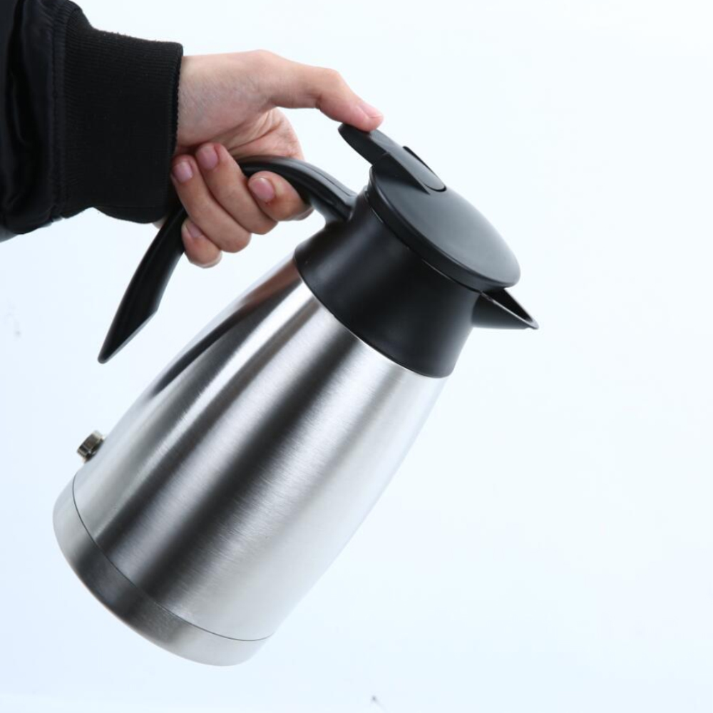 Eine Hand, die einen elektrischen Wasserkocher aus Edelstahl hält. Weißer Hintergrund.