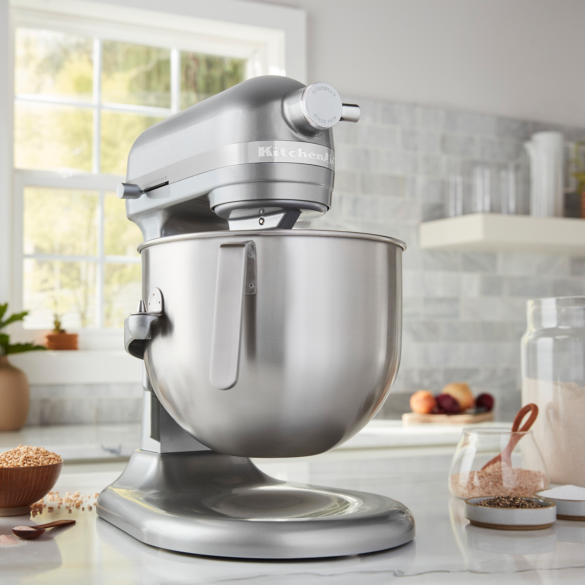 Ein silberner KitchenAid Standmixer steht auf einer Marmorarbeitsplatte.