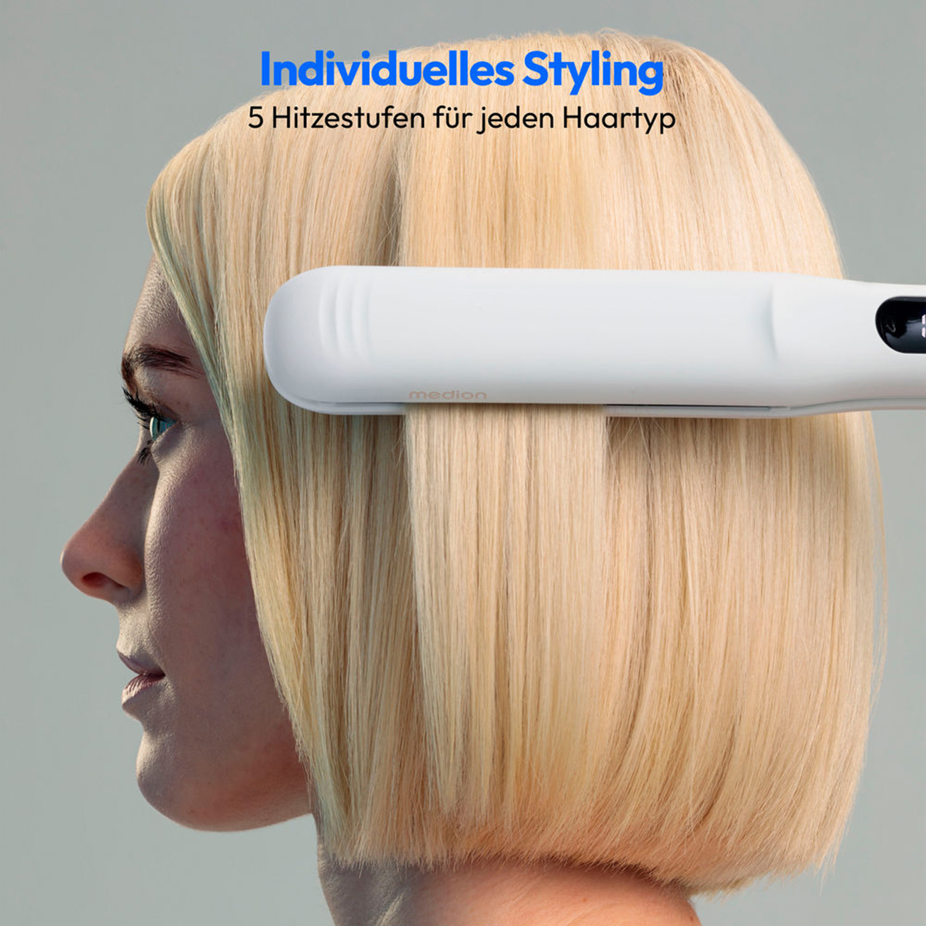 Kobieta prostująca włosy białą prostownicą.