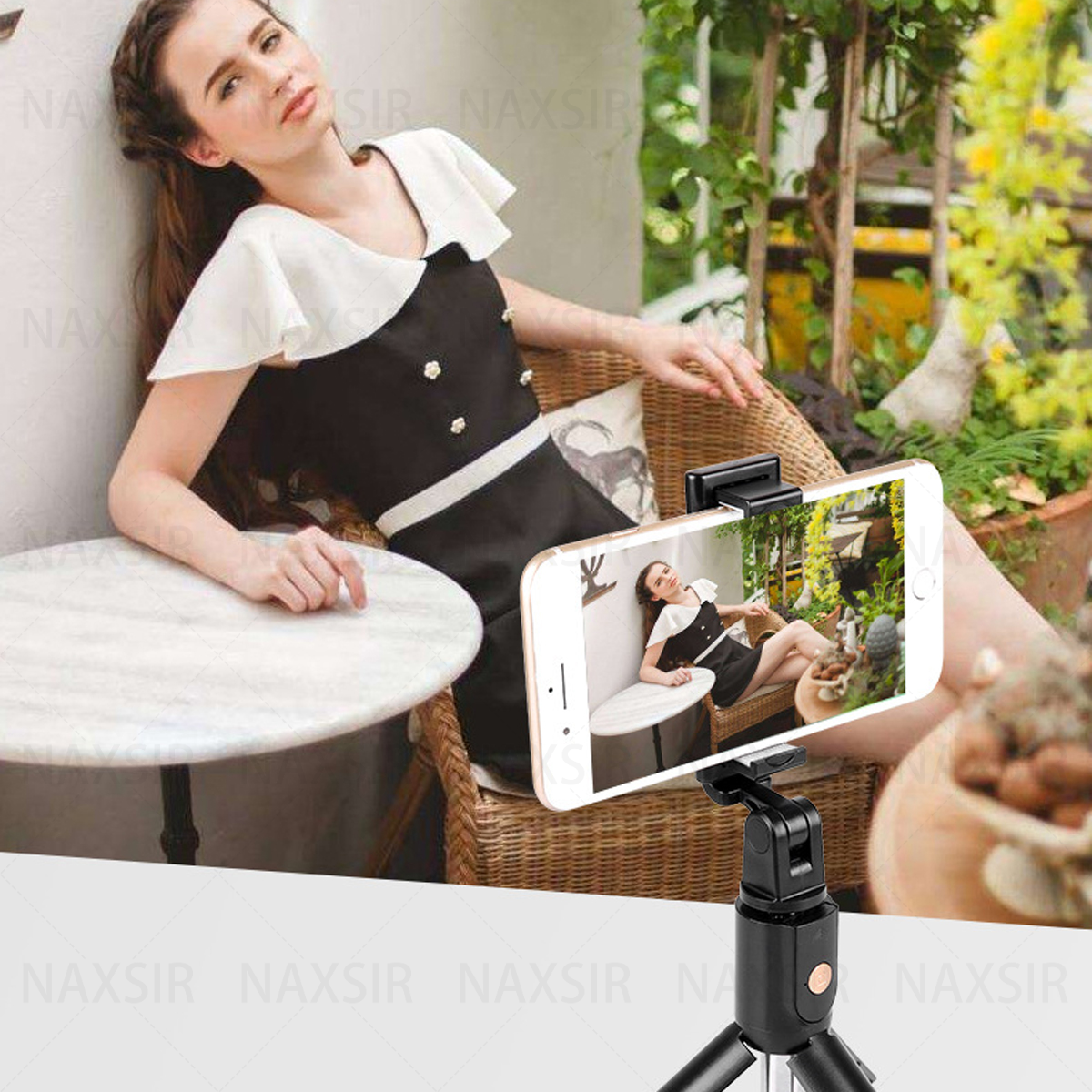 Frau macht ein Selfie mit einem Smartphone, das an einem Stativ befestigt ist. Sie sitzt.