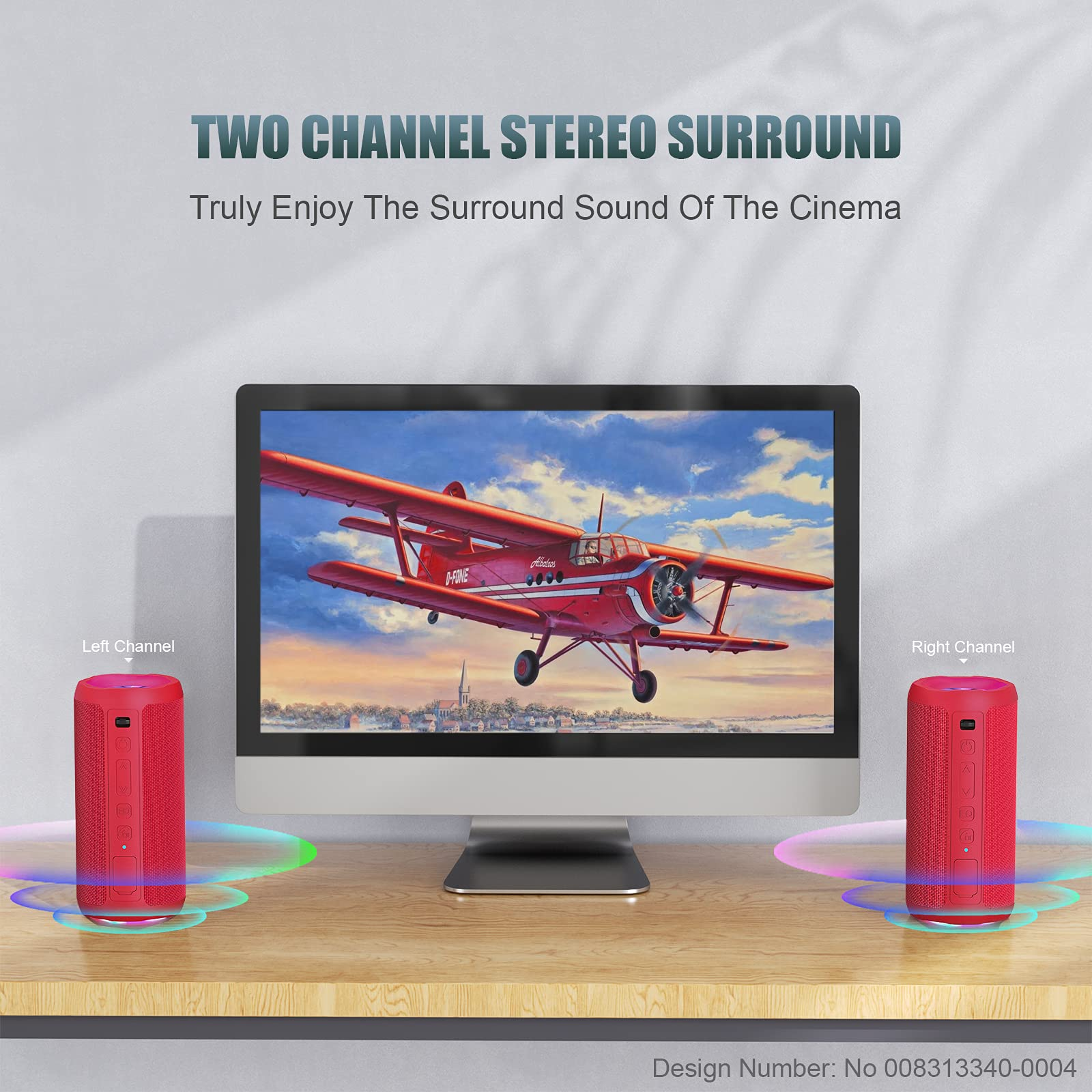 Ein Computermonitor mit einem roten Flugzeugbild, flankiert von zwei roten Lautsprechern auf einem Holztisch.