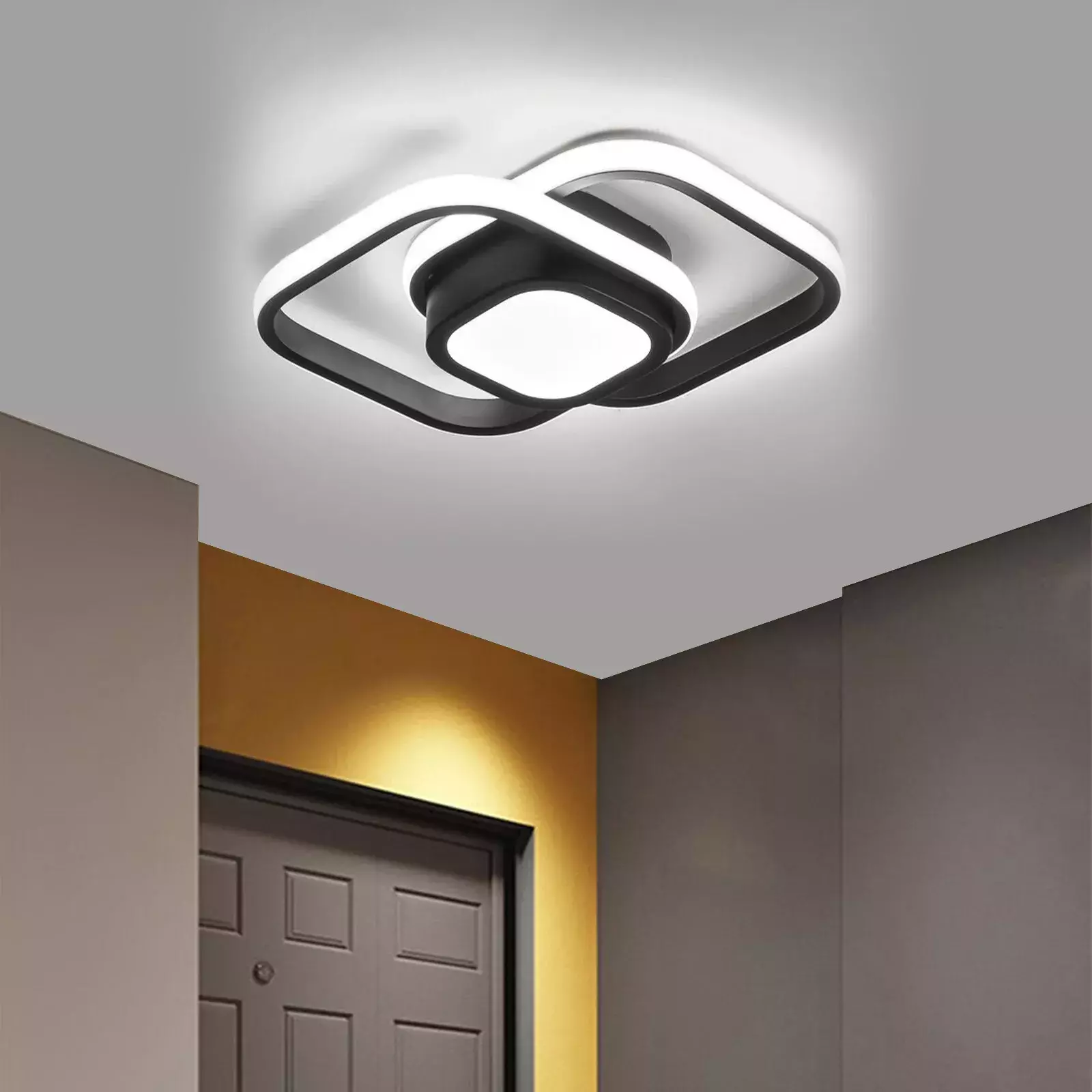 Moderne Deckenleuchte mit schwarzem quadratischem Design an einer weißen Decke über einem Türrahmen.