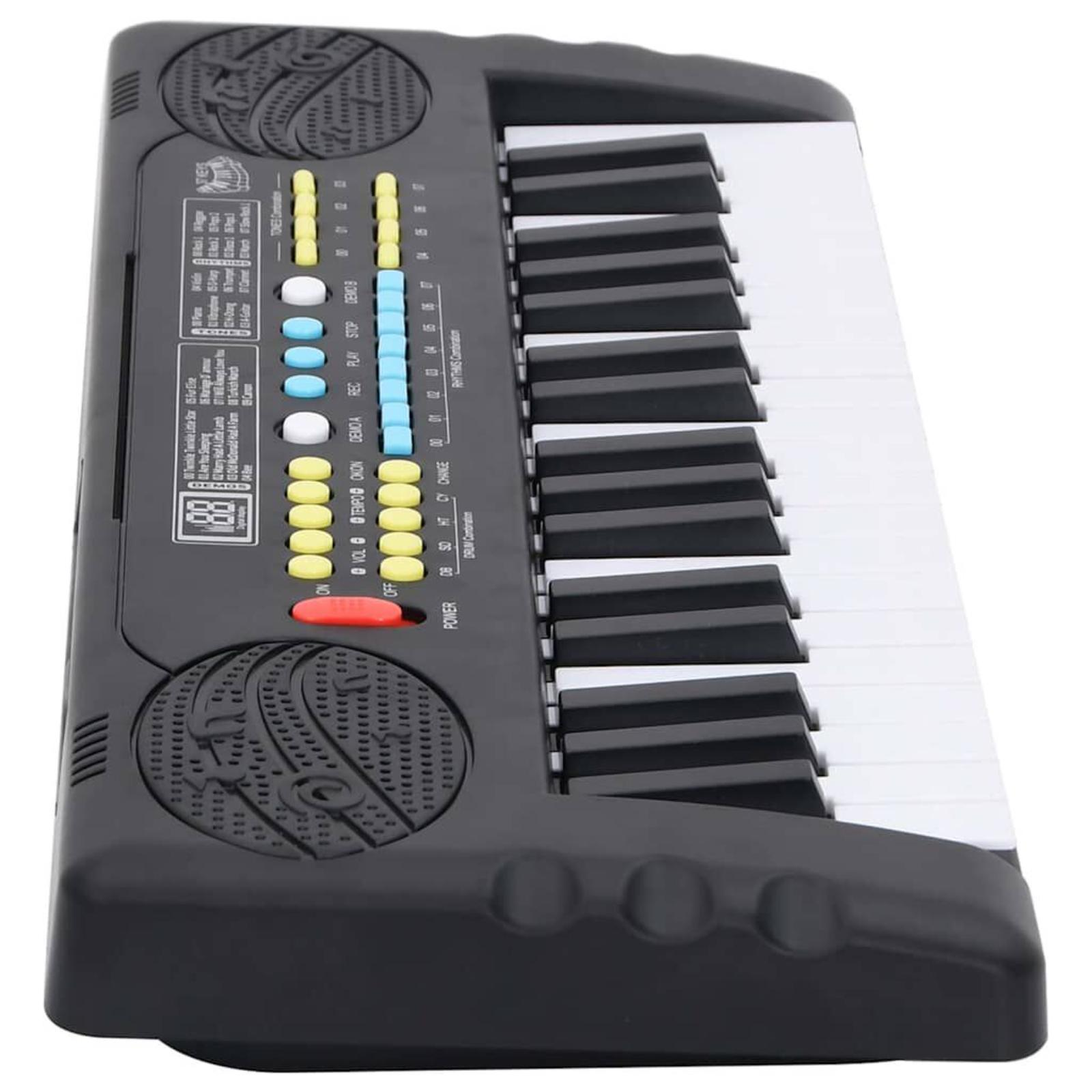 Schwarz-weißes Spielzeugkeyboard mit verschiedenen Knöpfen und einem roten Power-Knopf.