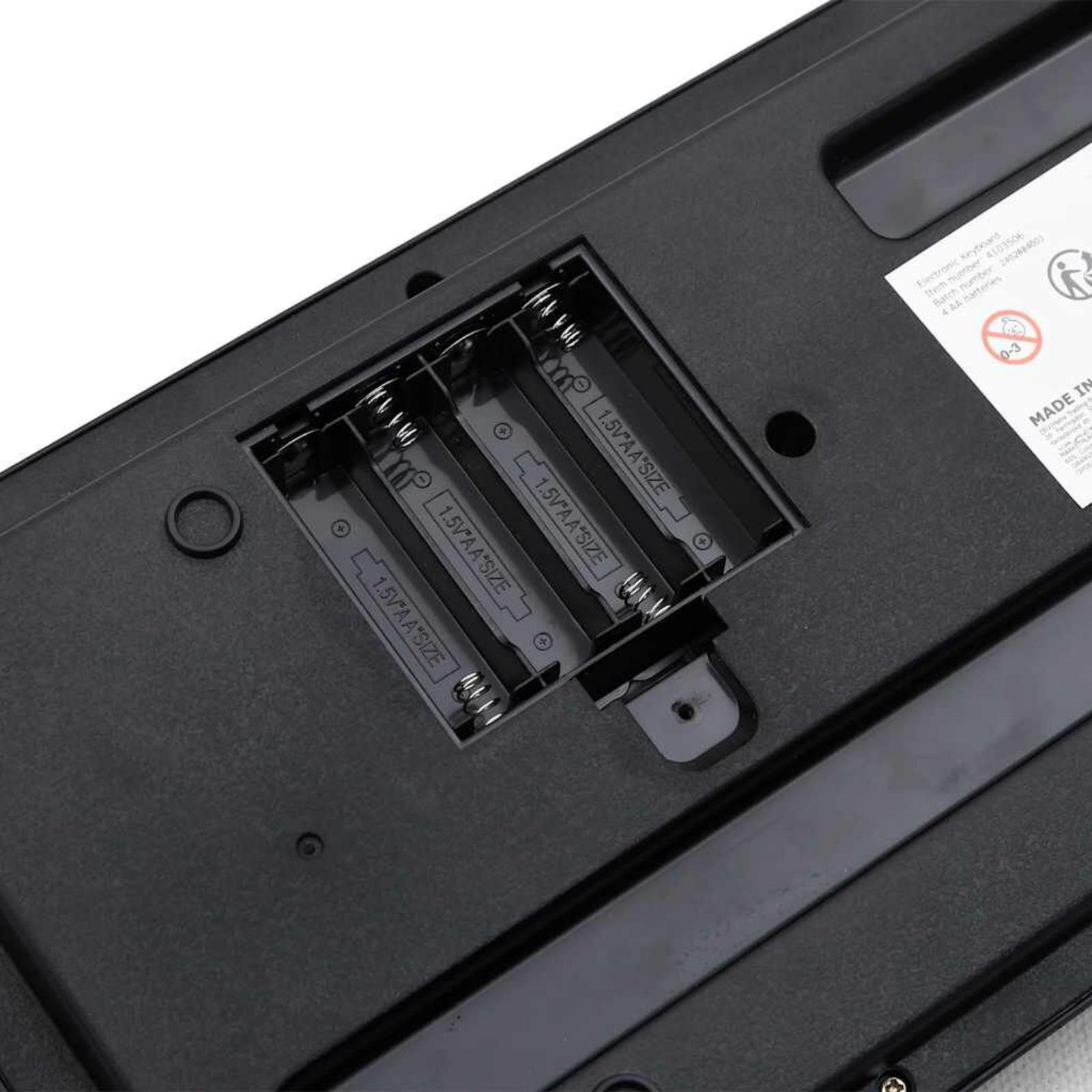 Das Batteriefach einer Spielzeugklaviatur mit drei Batterien.