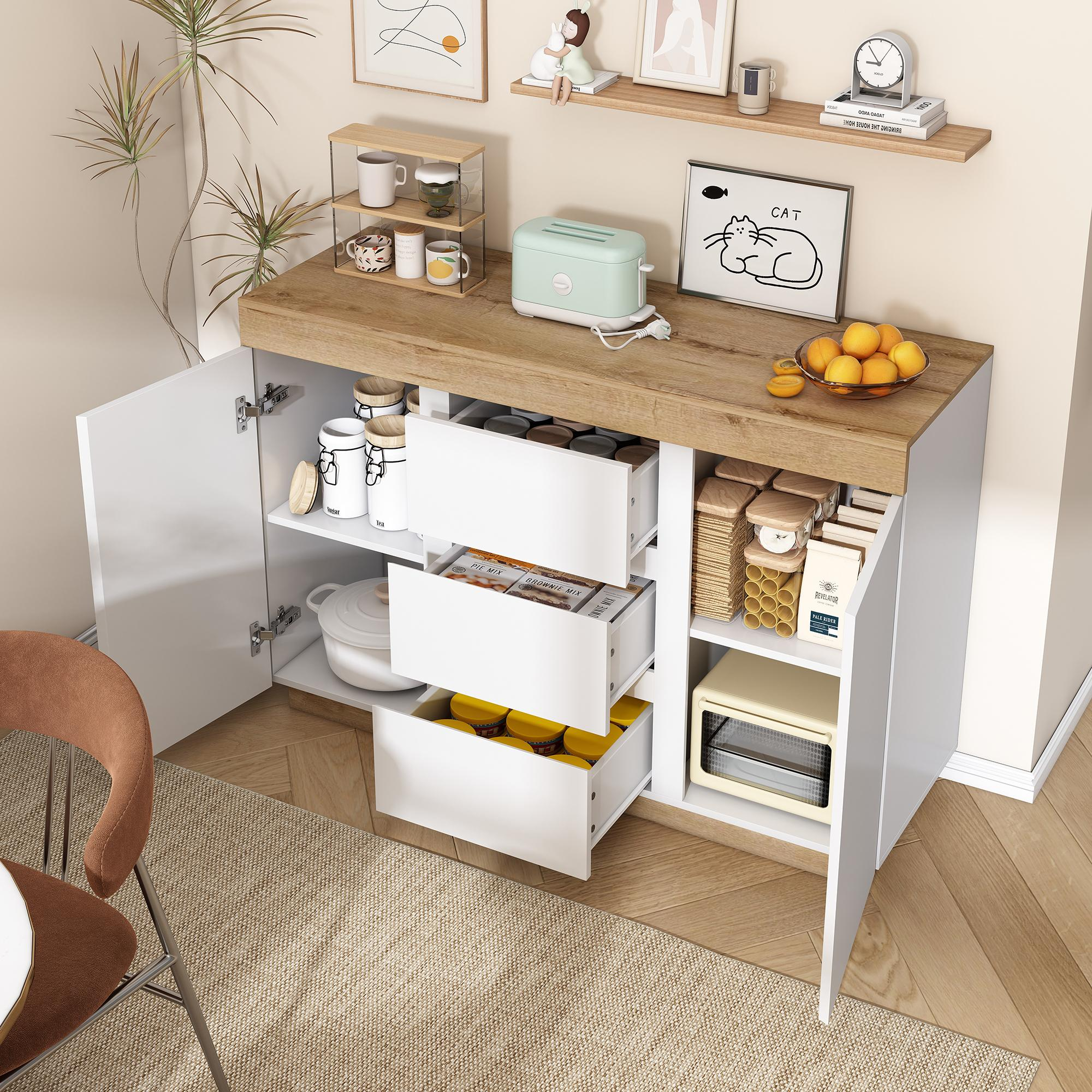 Ein weißes und hölzernes Sideboard mit Schubladen und offenen Schränken. Es gibt verschiedene Gegenstände darin und darauf.
