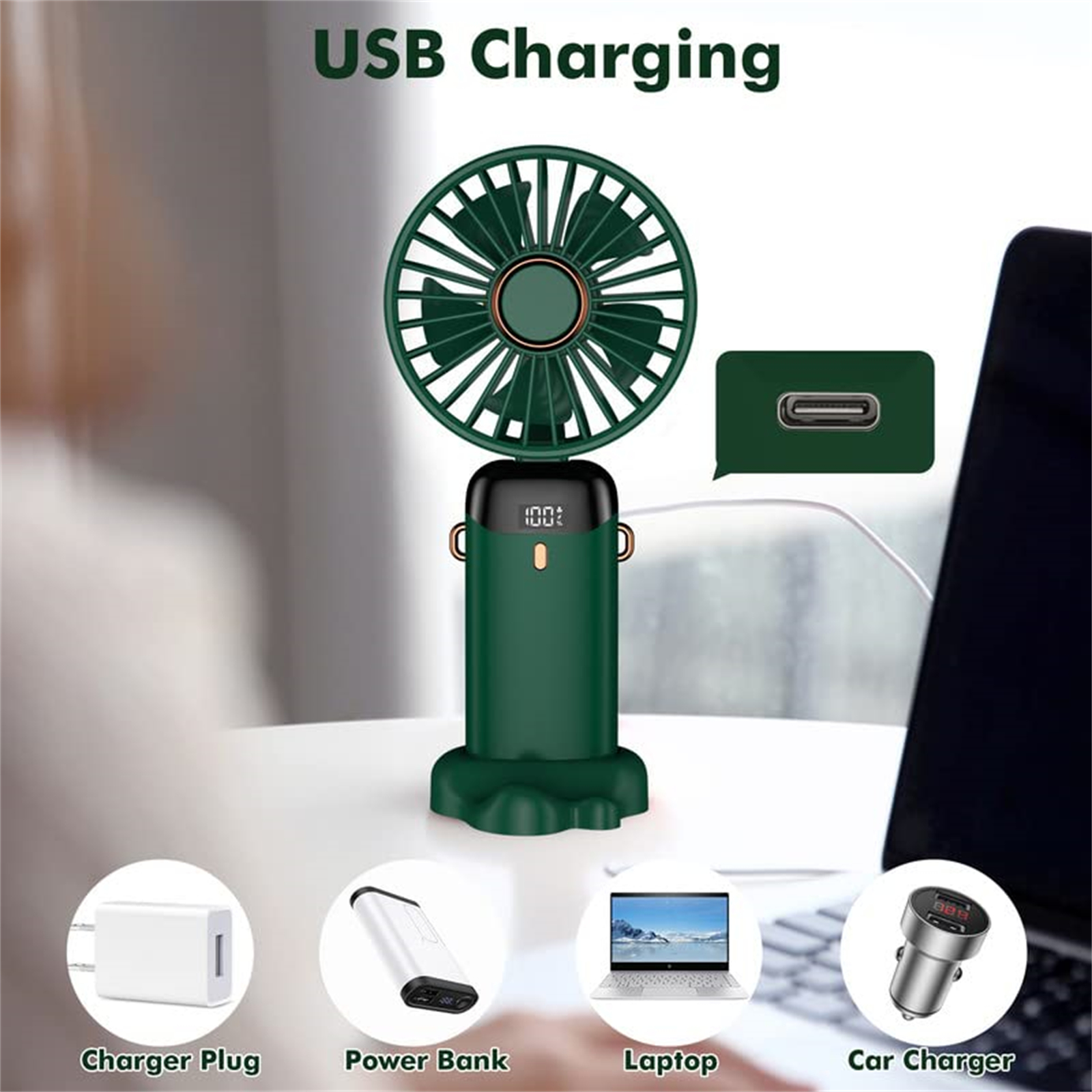 Ein grüner Handventilator mit Ladesteckern und einem Laptop. Es steht auf einem Tisch.