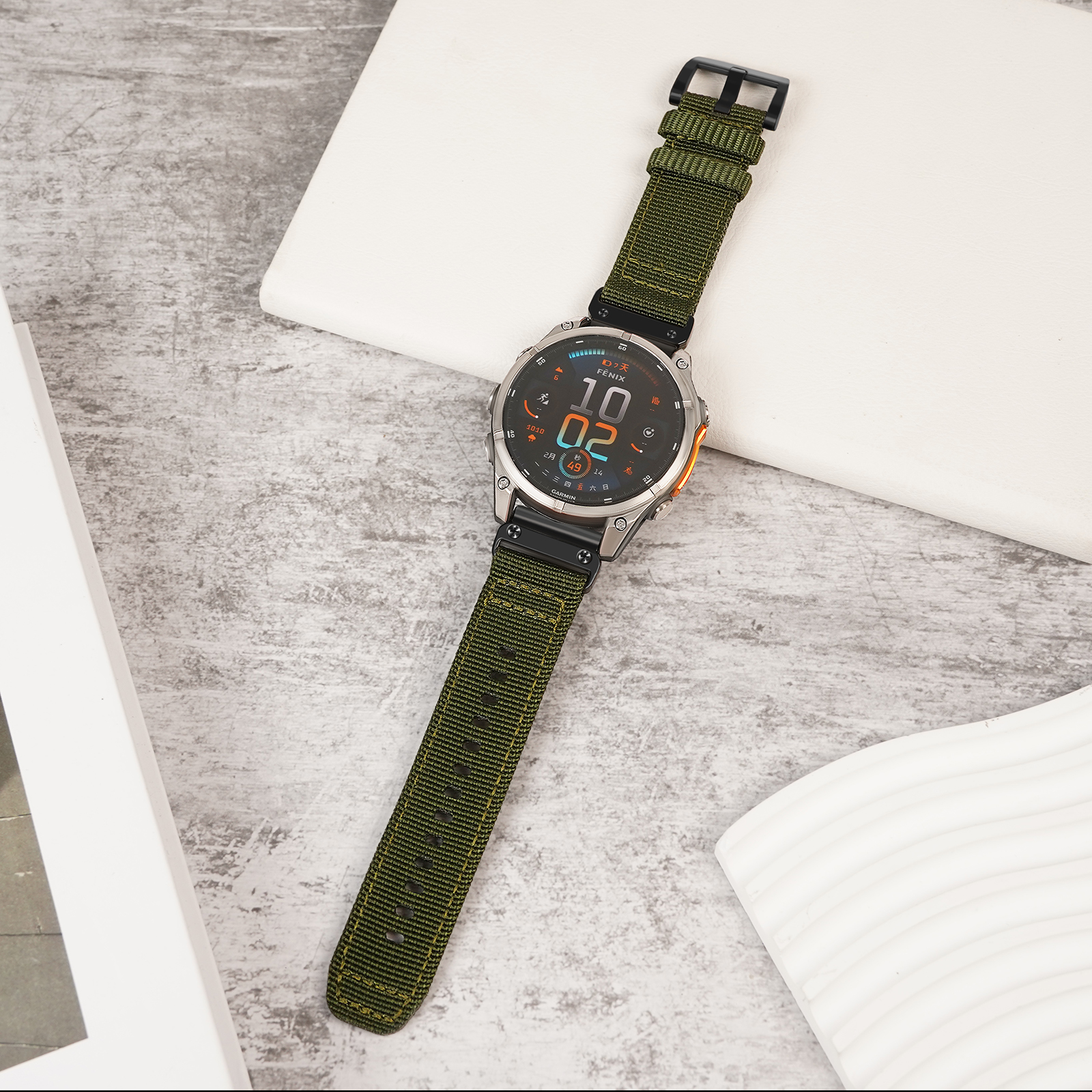 Un orologio con cinturino verde su un tavolo. Il quadrante mostra l'ora e i dati.