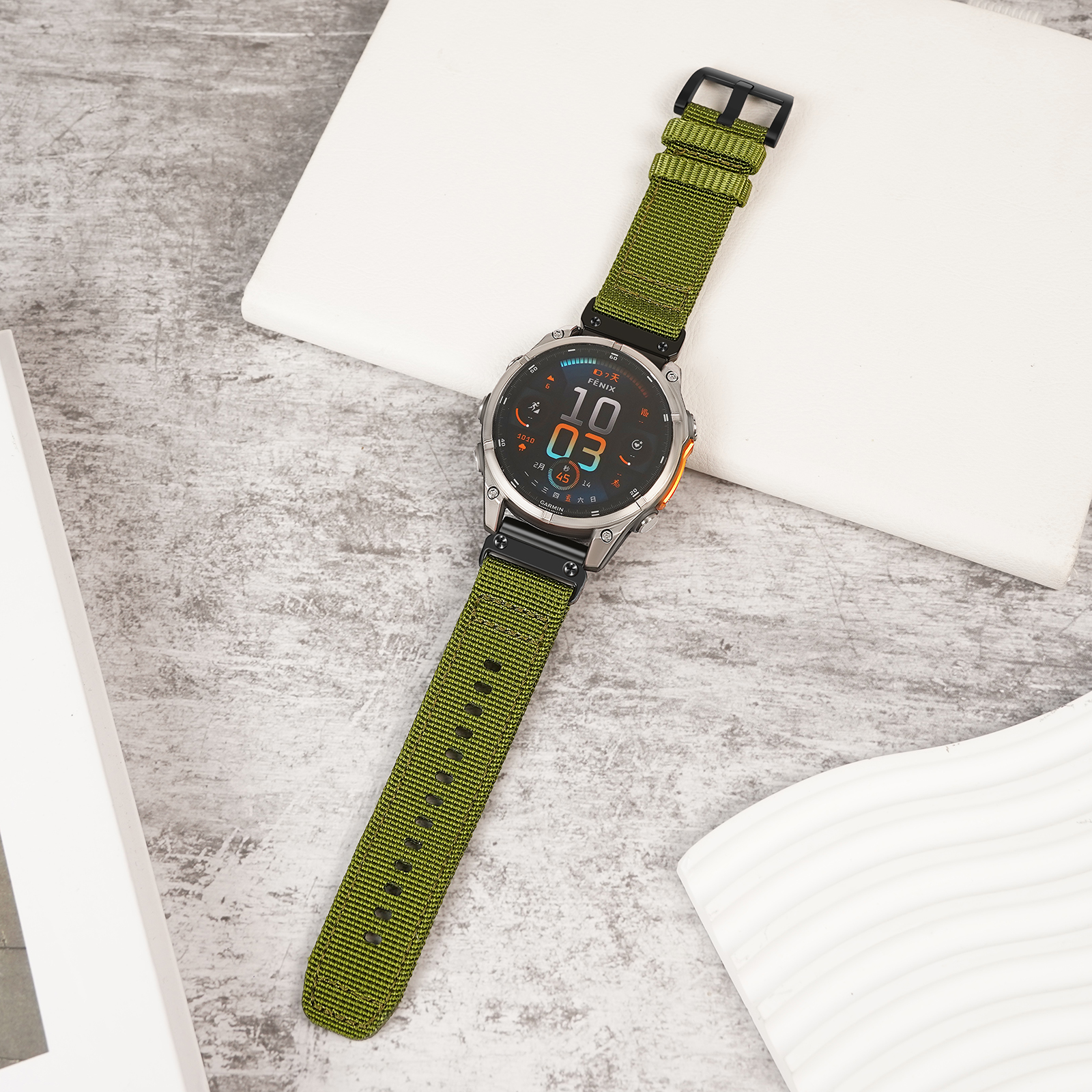 Orologio verde con cinturino verde su superficie bianca. Dettagli del quadrante visibili.