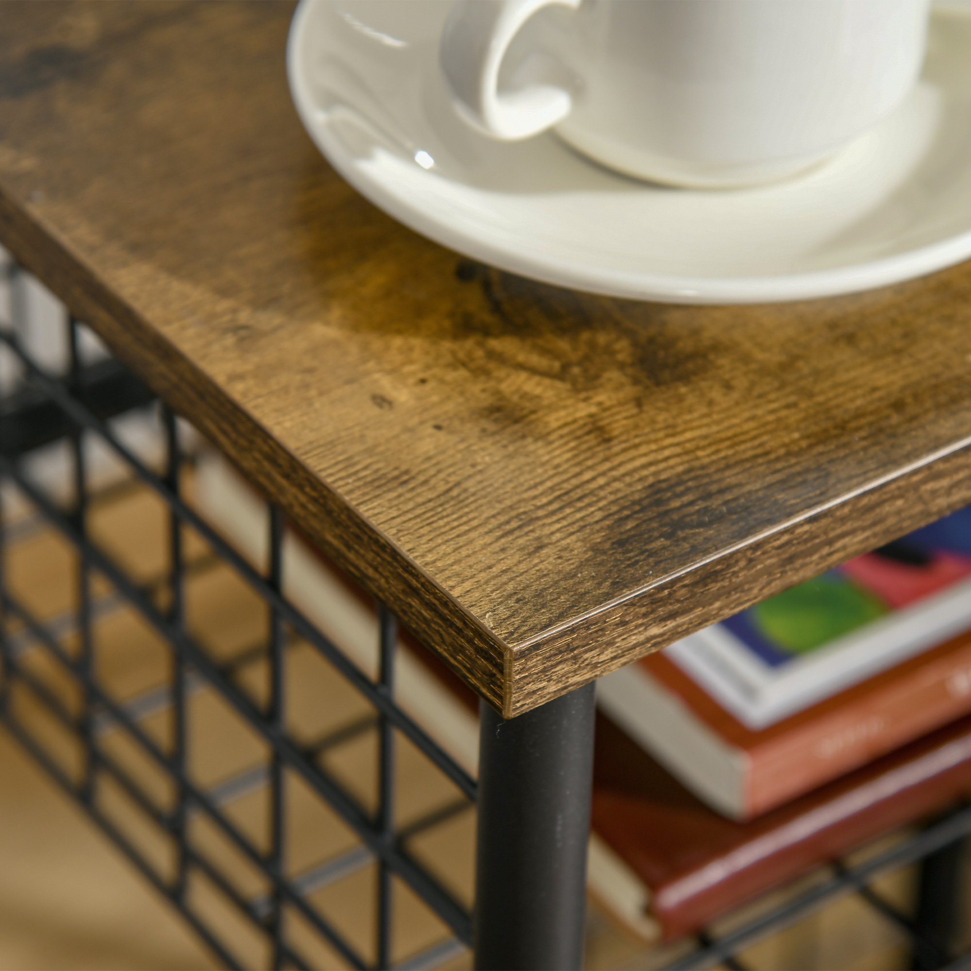 Nahaufnahme einer Holzoberfläche mit Tasse und Büchern auf einem Metallrahmen.