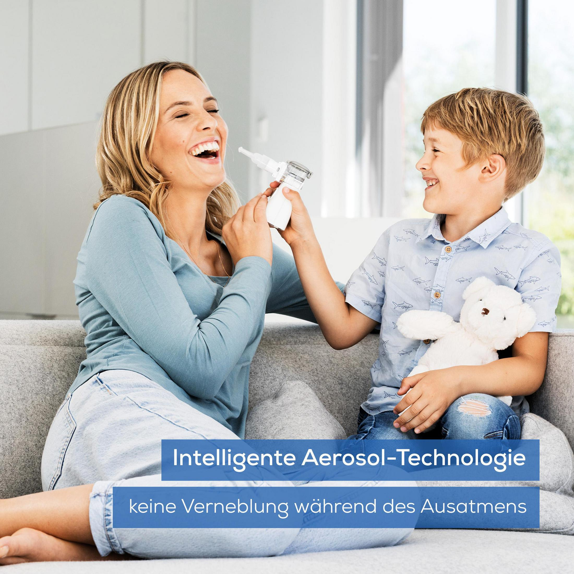 Frau und Junge auf einer Couch, spielen mit einem Inhalator.