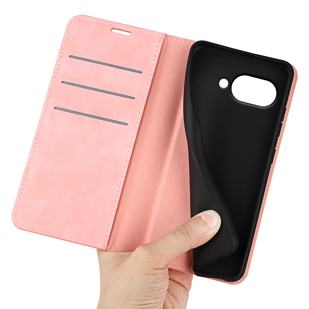 Een hand die een open roze telefoonhoes vasthoudt zonder telefoon, waardoor het zwarte interieur zichtbaar is.