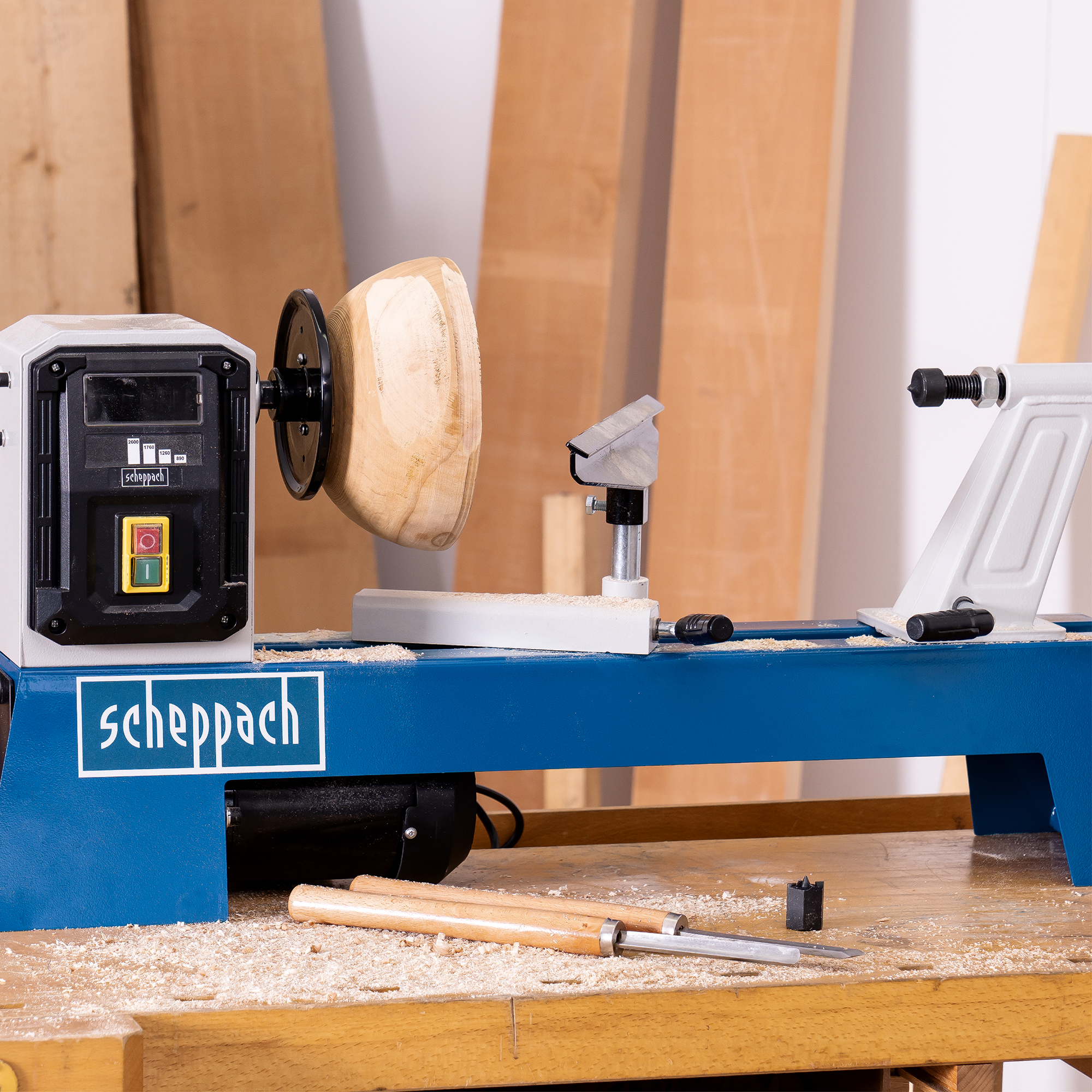 Una persona che utilizza un tornio per legno. Il legno viene modellato in una ciotola. Il marchio è Scheppach.