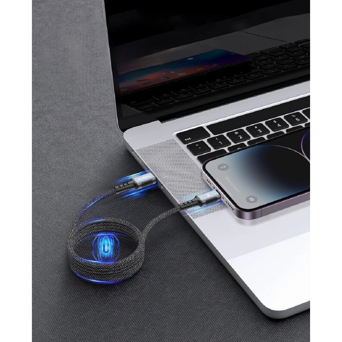Laptop, der über ein schwarz-weiß geflochtenes USB-C-Kabel mit einem Telefon verbunden ist. Das Kabel leuchtet.