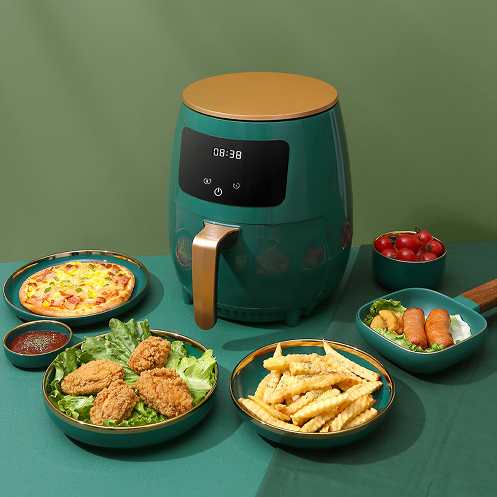 Grüne Heißluftfritteuse mit Essensplatten: Pizza, Brathähnchen, Pommes und kleine Schalen mit Soße und Tomaten.