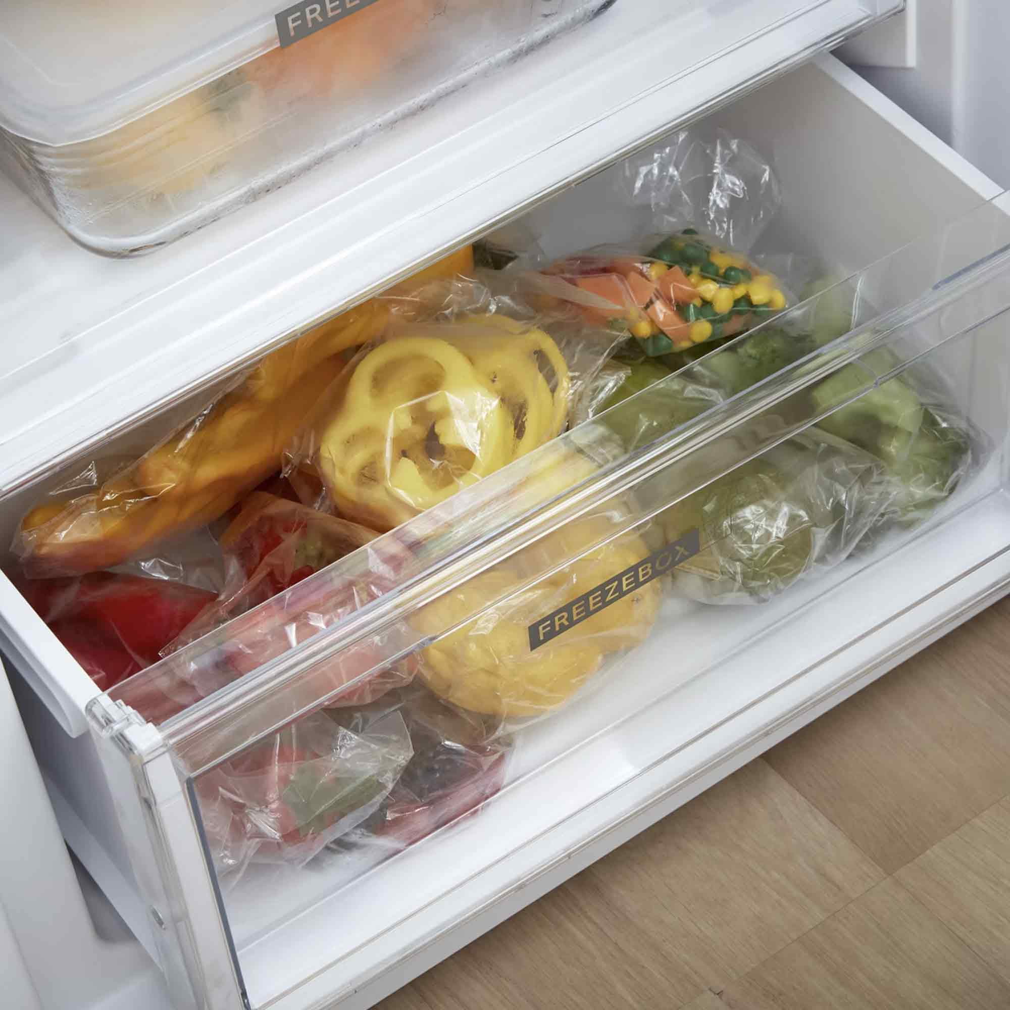 Eine Kühlschublade gefüllt mit verschiedenen Gemüsesorten in Plastiktüten.