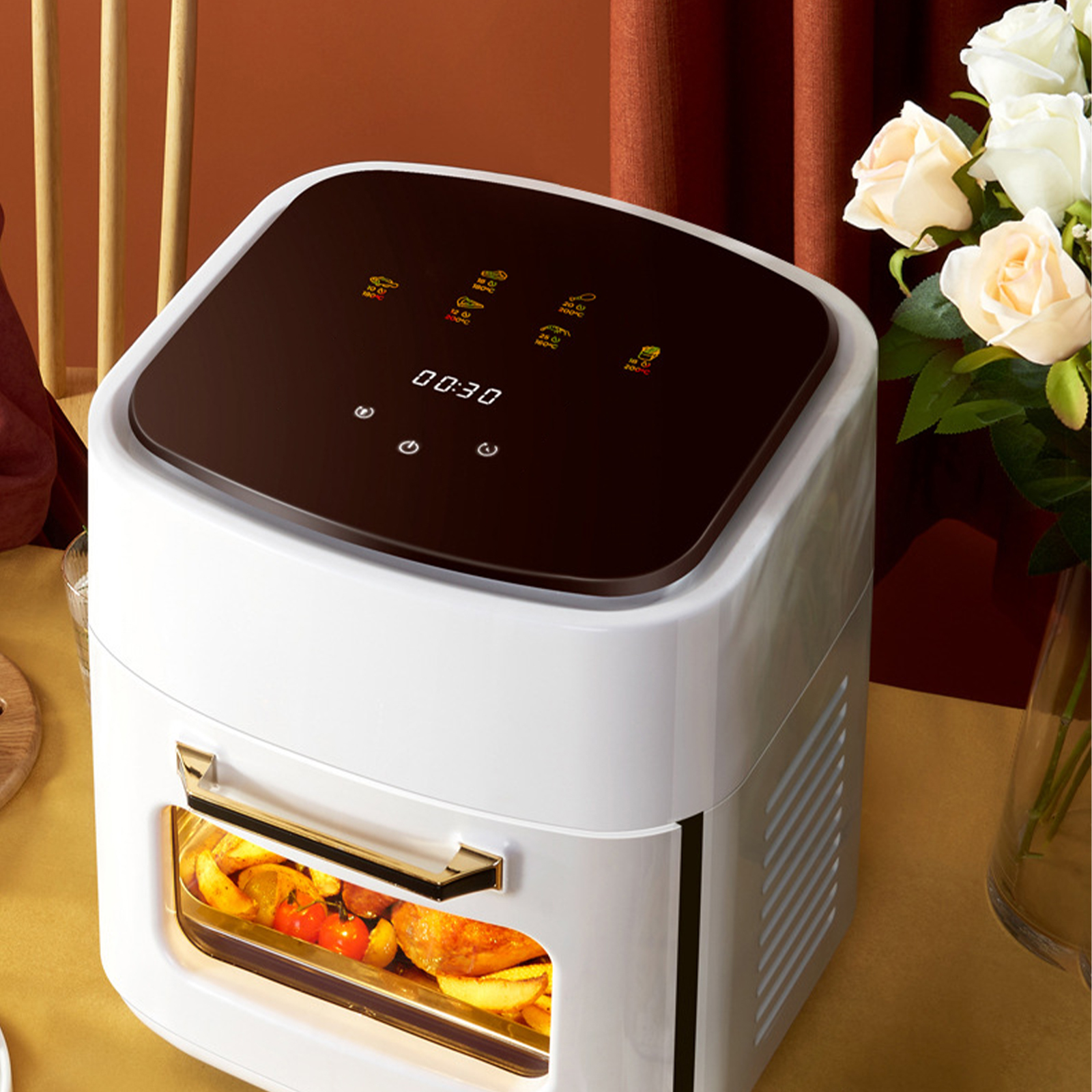 Weiß-schwarze Heißluftfritteuse mit Digitalanzeige. Sie steht auf einem Tisch mit Blumen.