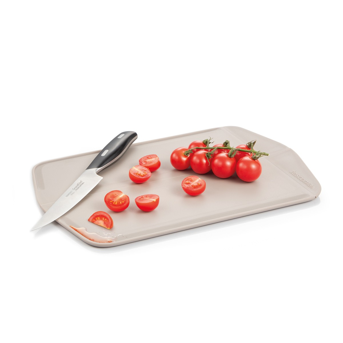 Schneidebrett mit Tomaten und Messer. Einige Tomaten sind halbiert.