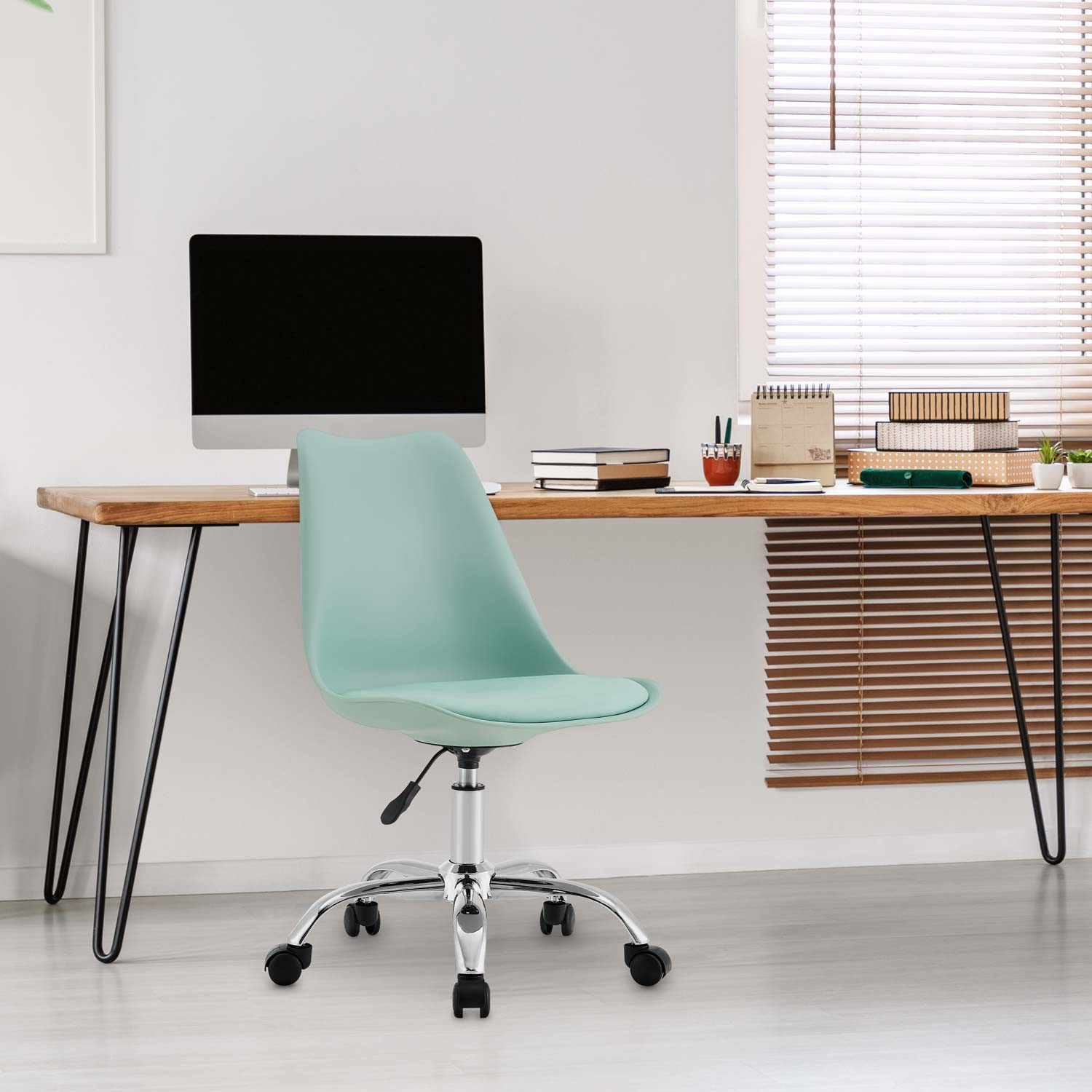 Configuración de oficina. Silla verde en escritorio de madera. Computadora y ventana visibles.