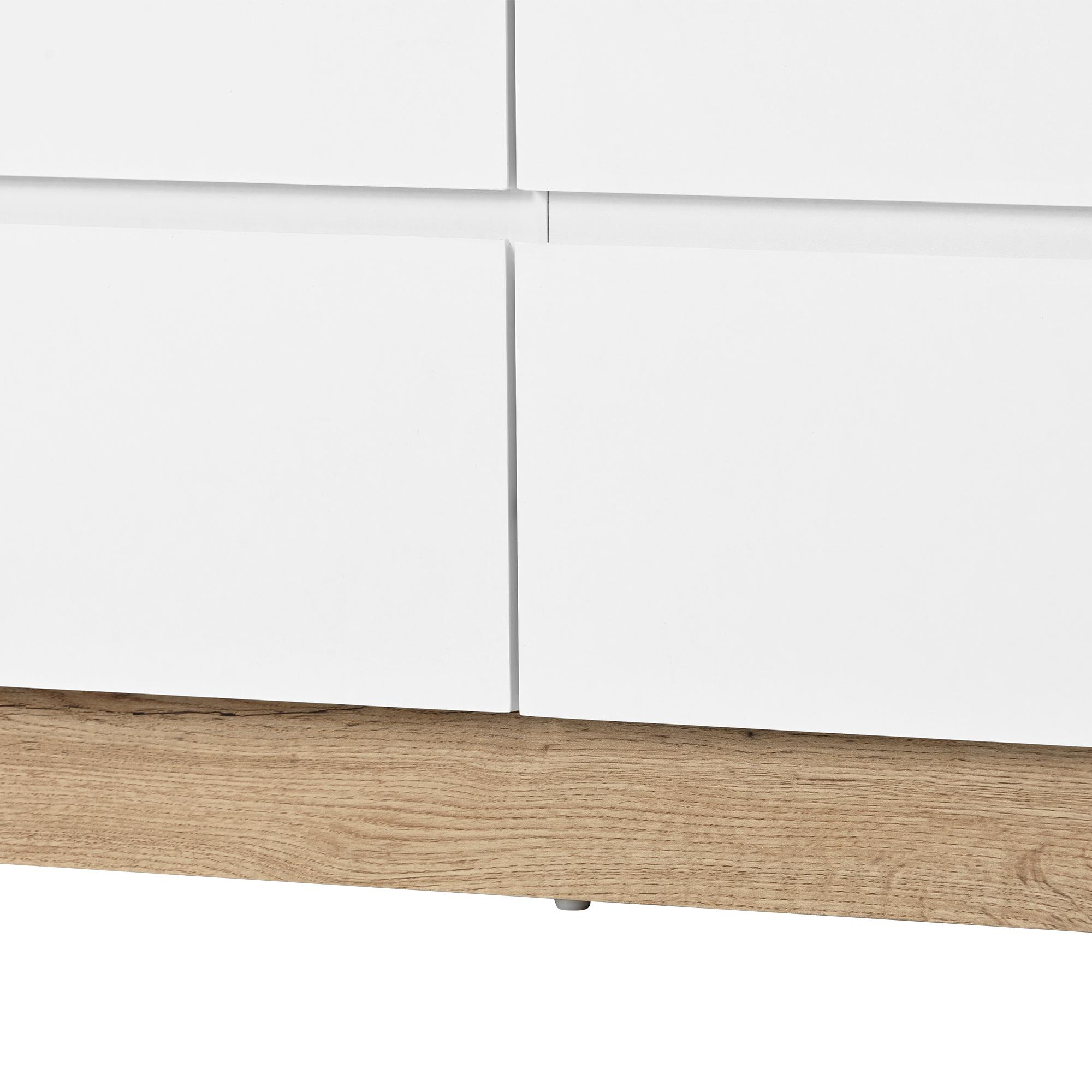 Nahaufnahme von weißen Kommodenschubladen mit Holzsockel.