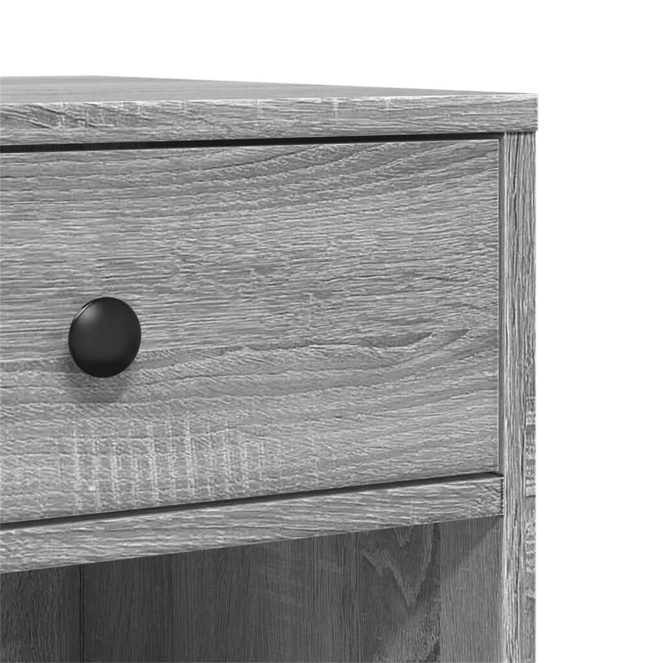 Nahaufnahme einer grauen Holzschublade mit einem schwarzen Knauf. Das Holz hat eine strukturierte Oberfläche.