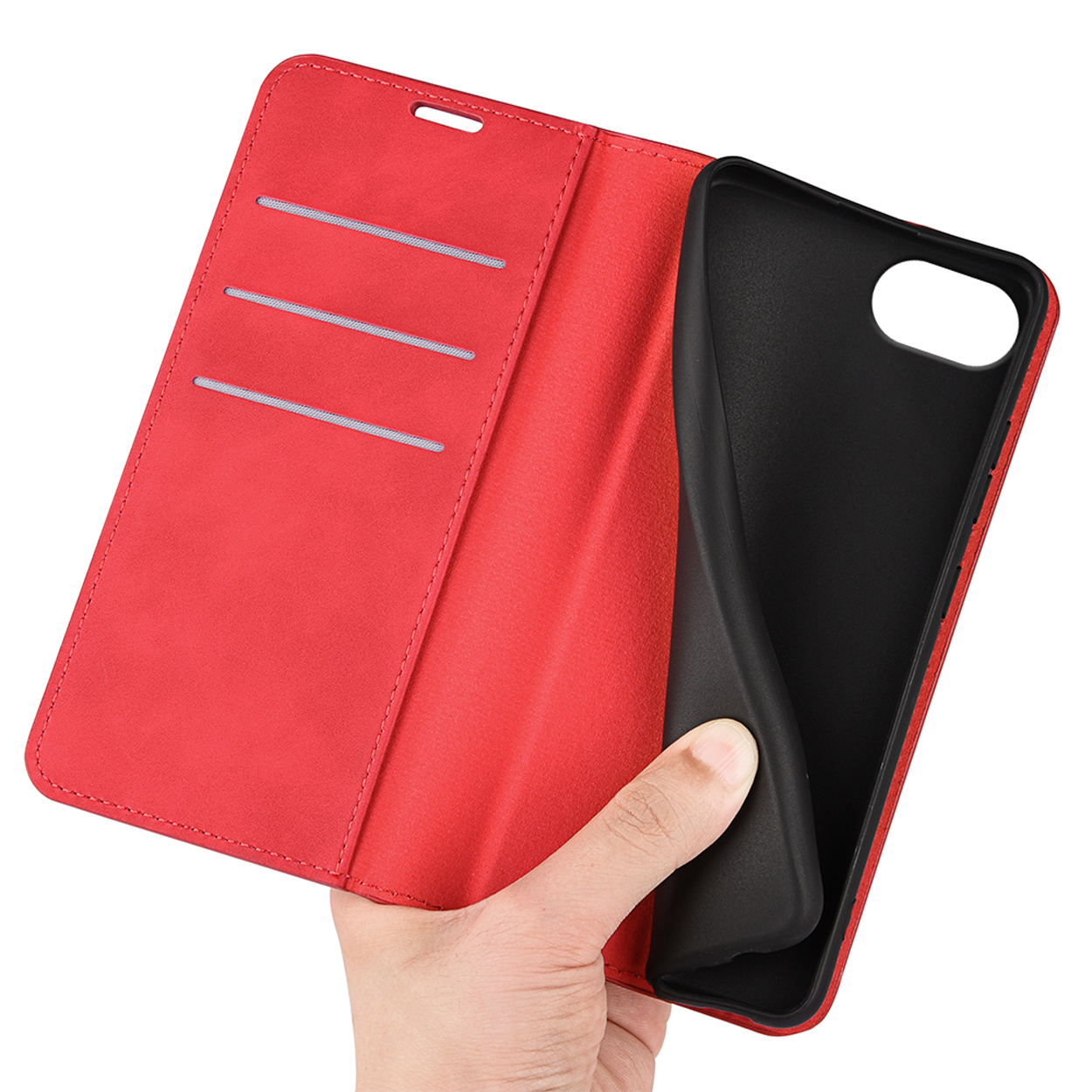 The inside of a red phone case. A hand is holding the phone in the case.