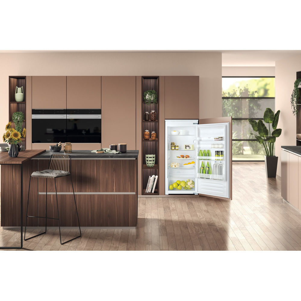 Una cucina moderna con un frigorifero con la porta aperta. La cucina ha mobili in legno e un bancone.