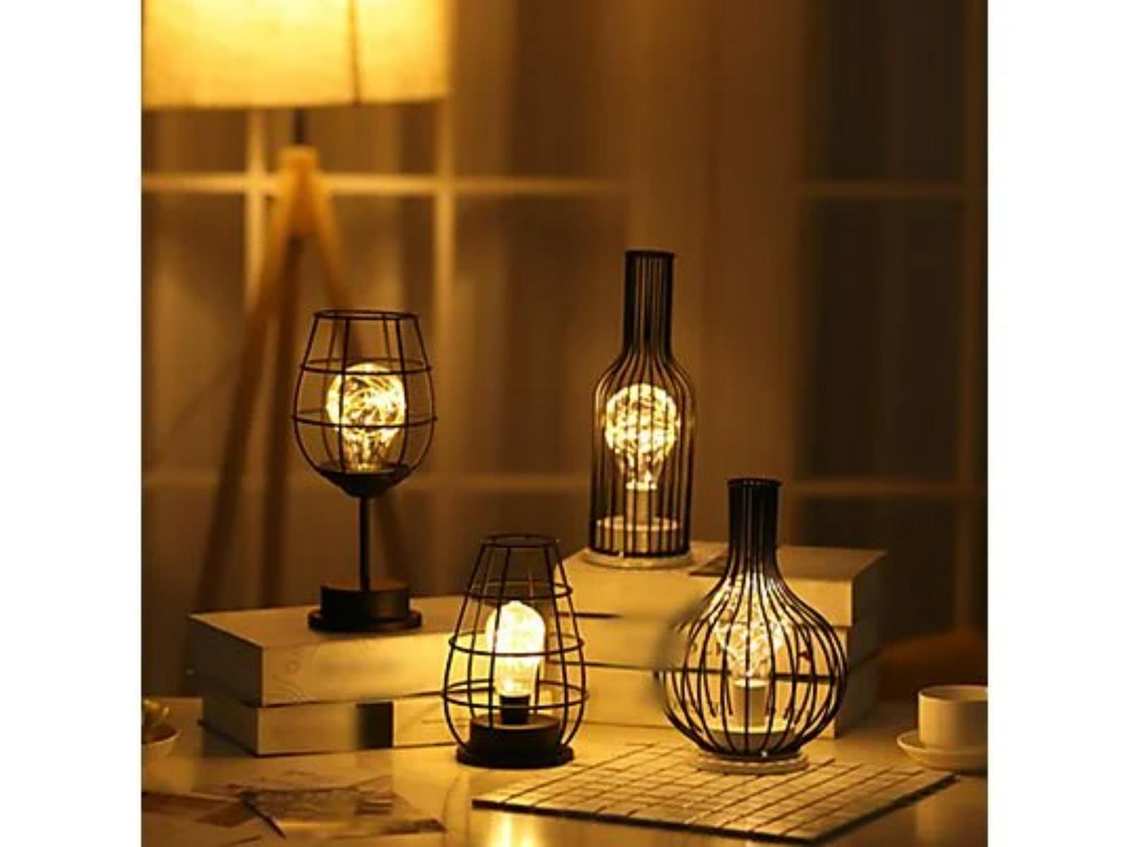Dekorative Lampen in Flaschenform. Gedämpfte Beleuchtung. Bücher auf dem Tisch.