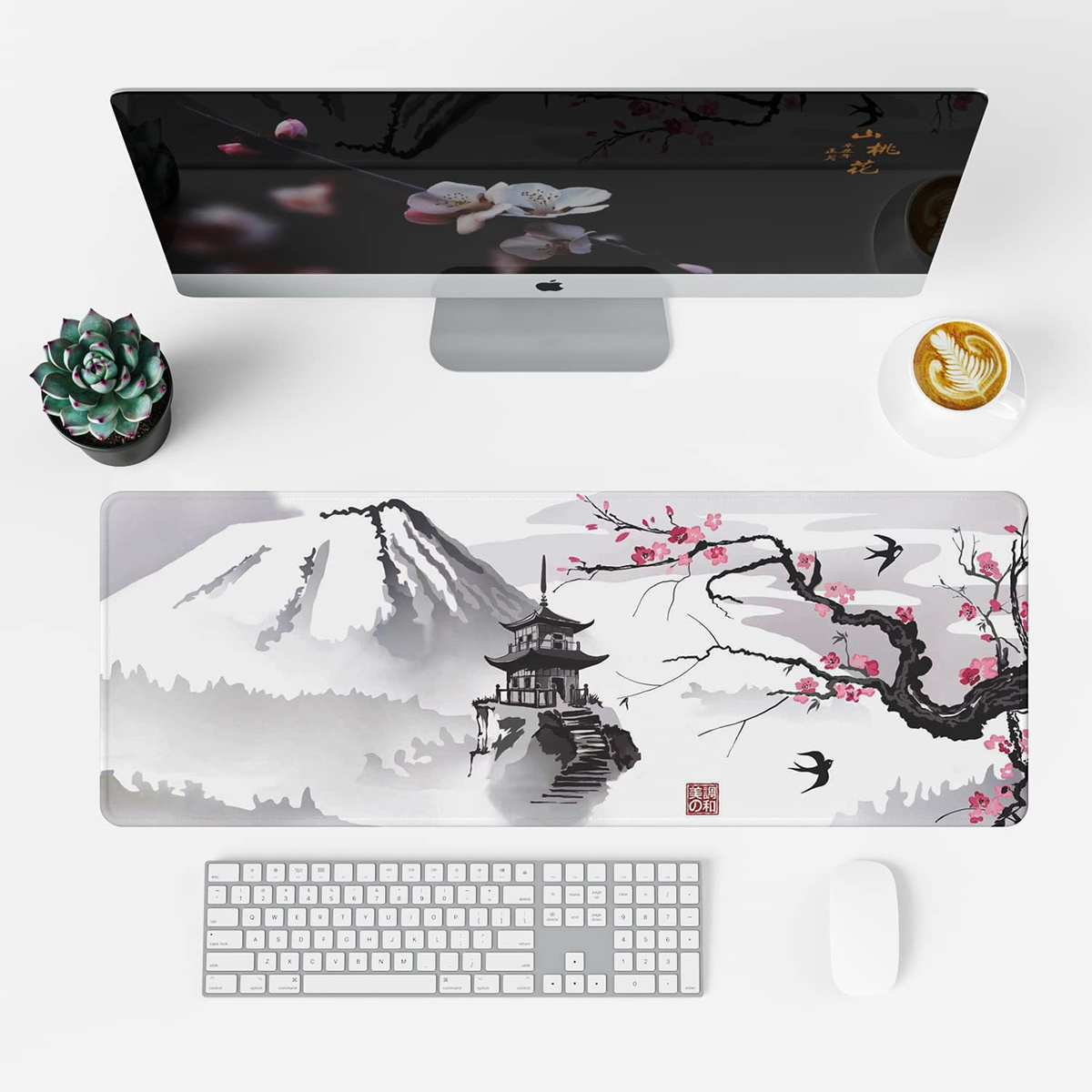 Draufsicht auf einen Schreibtischaufbau. Der Monitor zeigt Kirschblütenkunst. Tastatur, Maus und Sukkulente sind vorhanden.