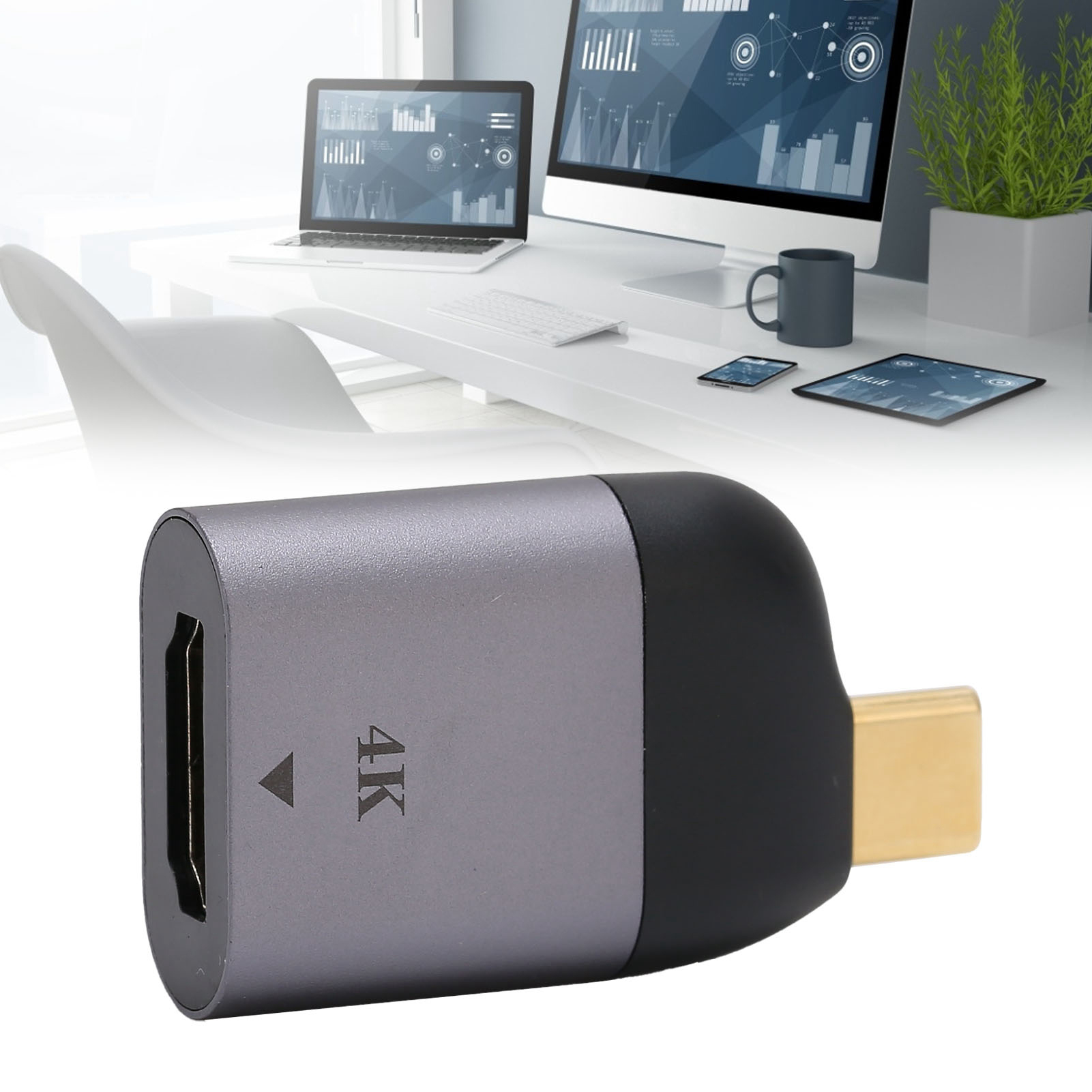 Ein Desktop-Setup mit einem silbernen HDMI-zu-USB-C-Adapter im Vordergrund.