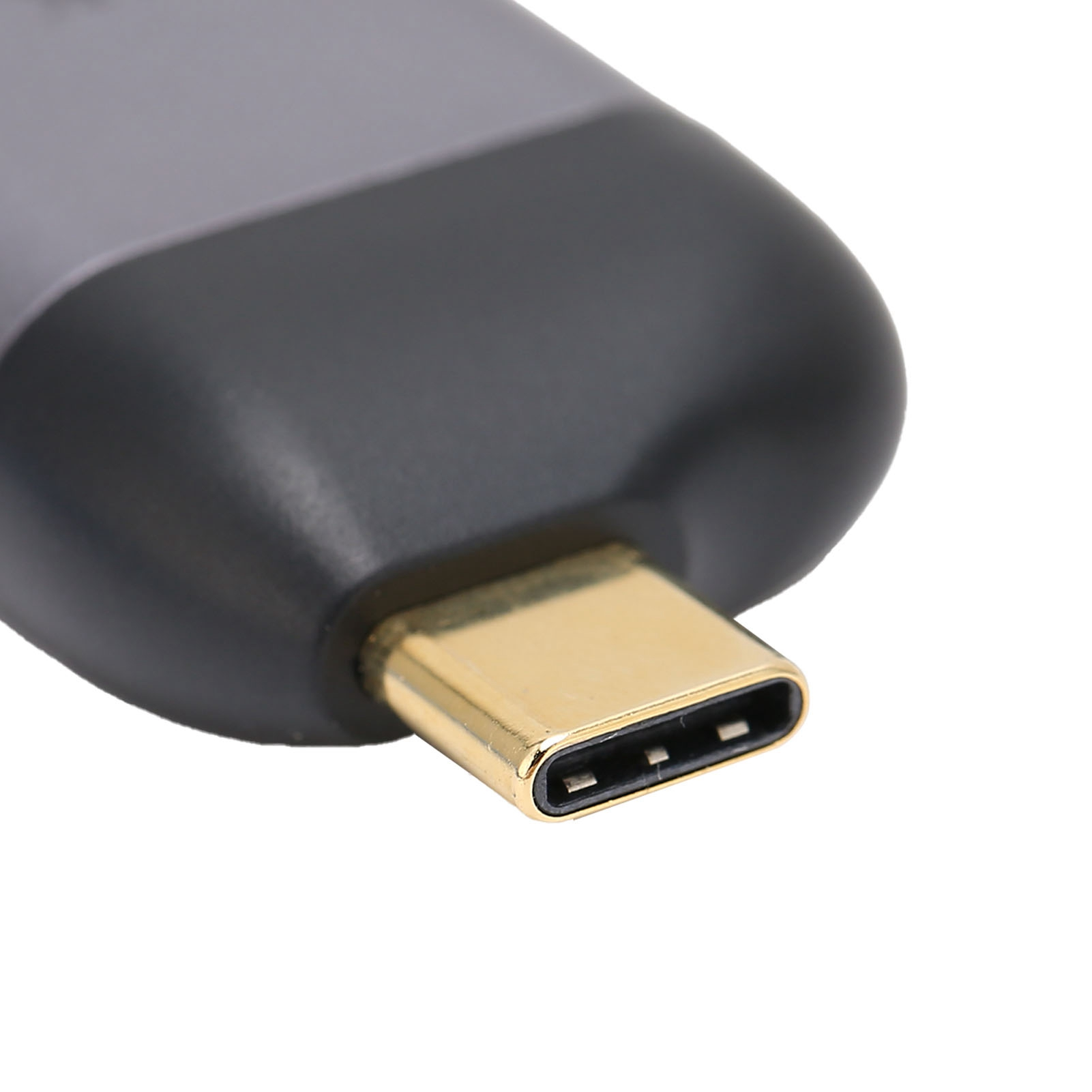 Nahaufnahme eines goldfarbenen USB-C-Anschlusses. Schwarzes Adaptergehäuse. Weißer Hintergrund.