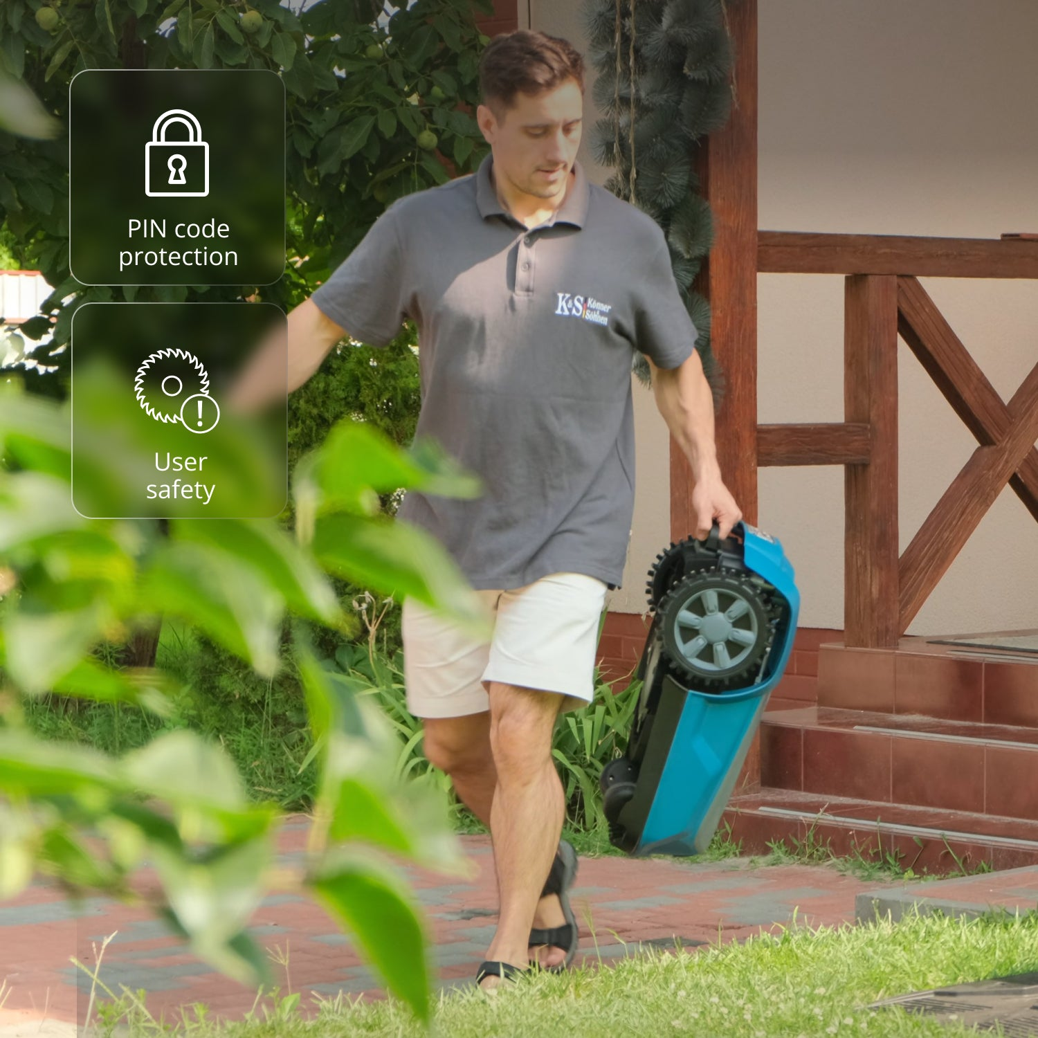 Hombre lleva cortacésped robot azul, camina sobre hierba. Fondo casa. Información de seguridad.