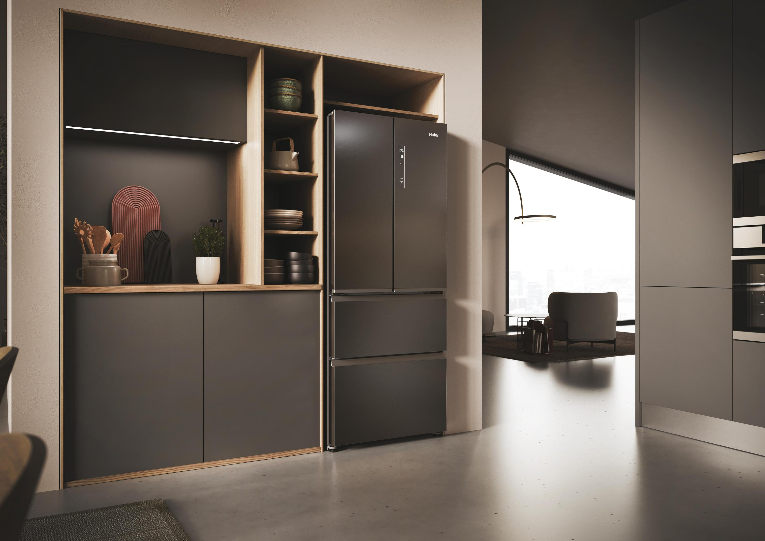 Un frigorifero nero in una cucina moderna. Gli scaffali sono visibili accanto. Il pavimento è in cemento.