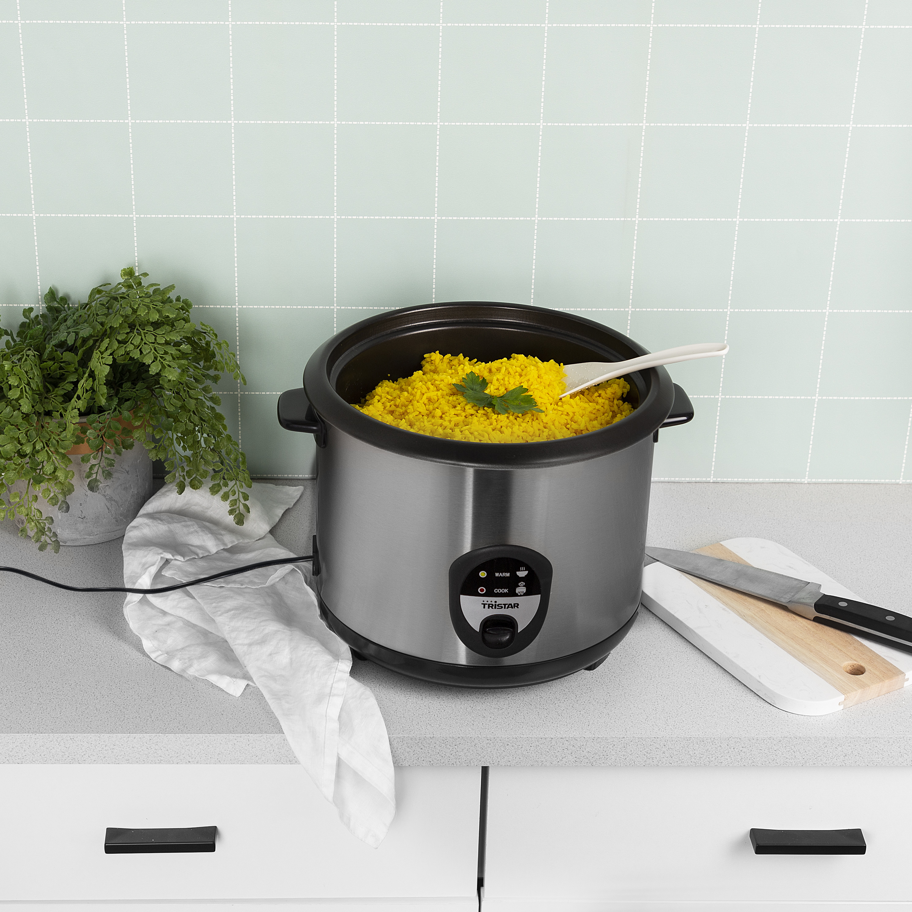 Una donna con capelli mossi e due styler per capelli. Gli styler sono argento e rosa.