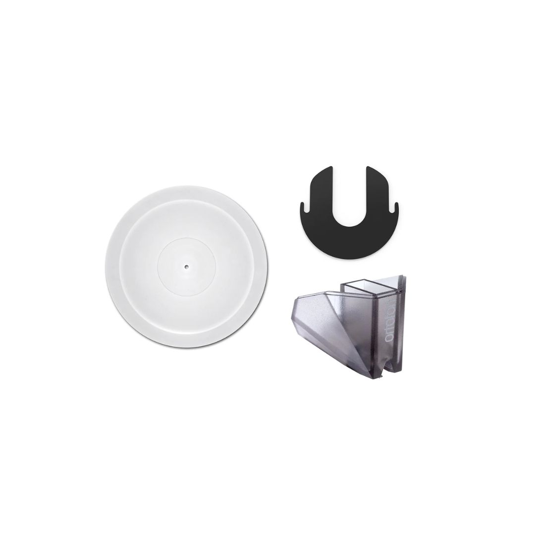 Białe przedmioty: płyta, czarny element w kształcie litery U i przezroczysty element z tworzywa sztucznego.