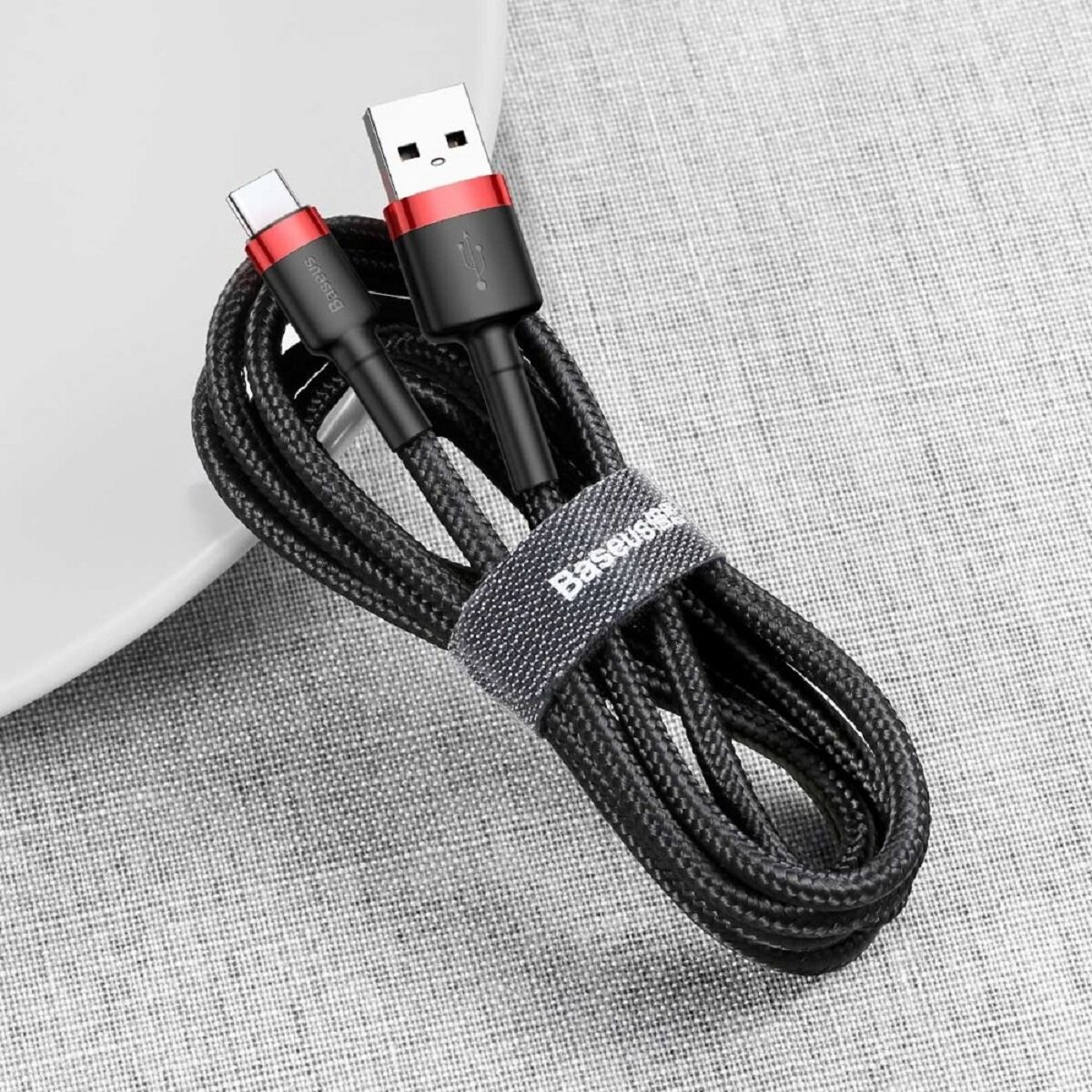 Czarny kabel USB-C do USB-A z czerwonymi akcentami, pleciony i z paskiem marki Baseus.