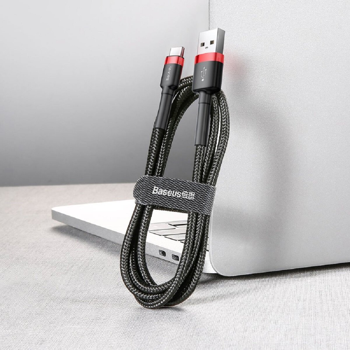 Czarny kabel USB-C do USB-A z czerwonymi akcentami, pleciony i z paskiem marki Baseus.