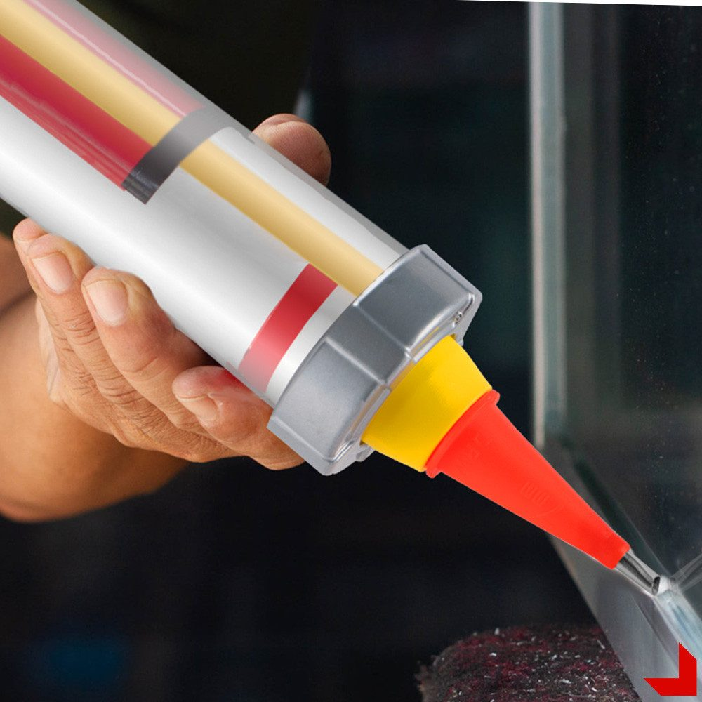 Eine Hand, die mit einer rot-gelben Düse Dichtmittel auf ein Glasaquarium aufträgt.
