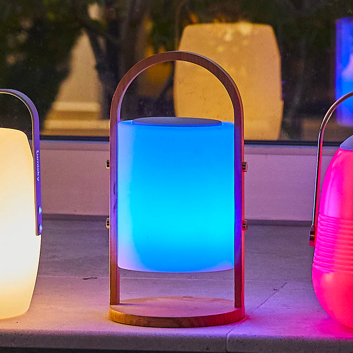 Una lampada Lumisky che emette luce blu, posta su una sporgenza con altre lampade. Le lampade sono in fila.