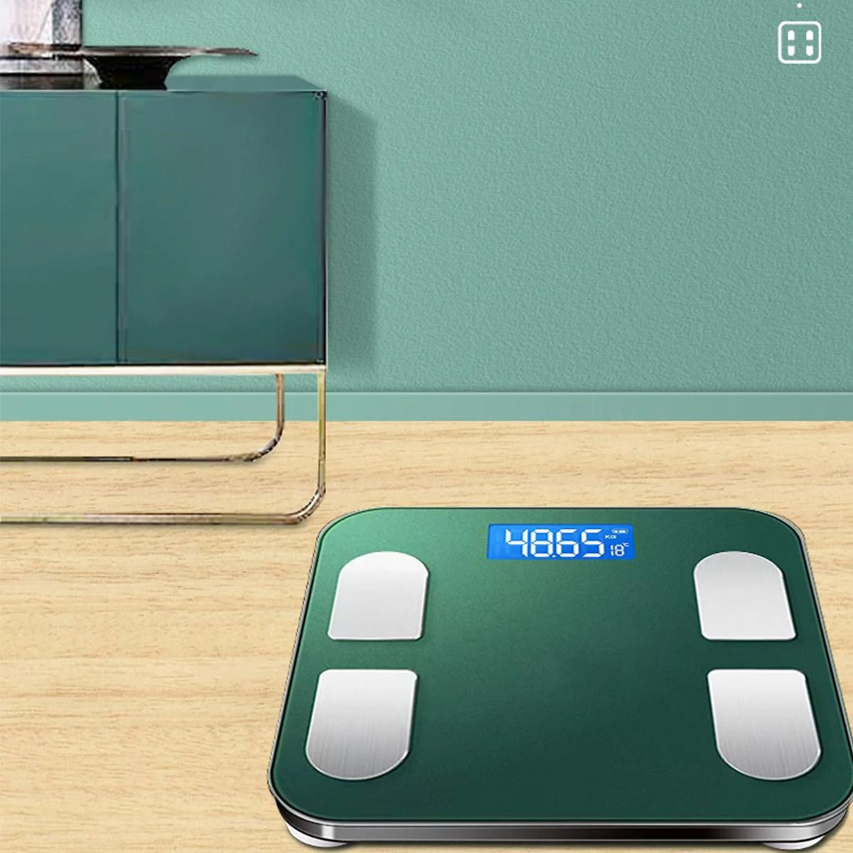 Eine grüne intelligente Waage mit einem Gewicht von 48,65 kg und ein Schrank im Hintergrund.