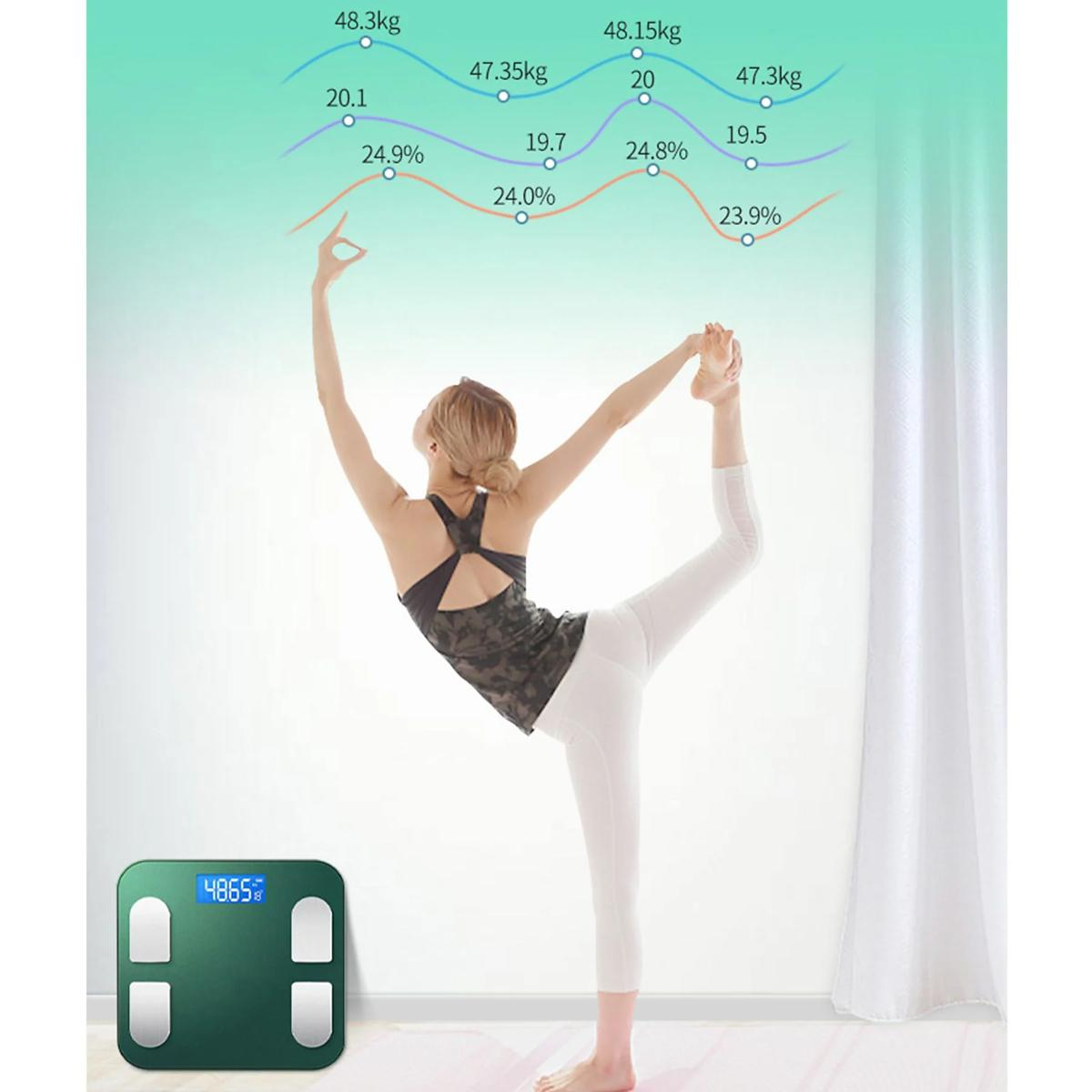 Frau macht Yoga-Pose mit einer intelligenten Waage, die Körpermetriken und Diagramme anzeigt.