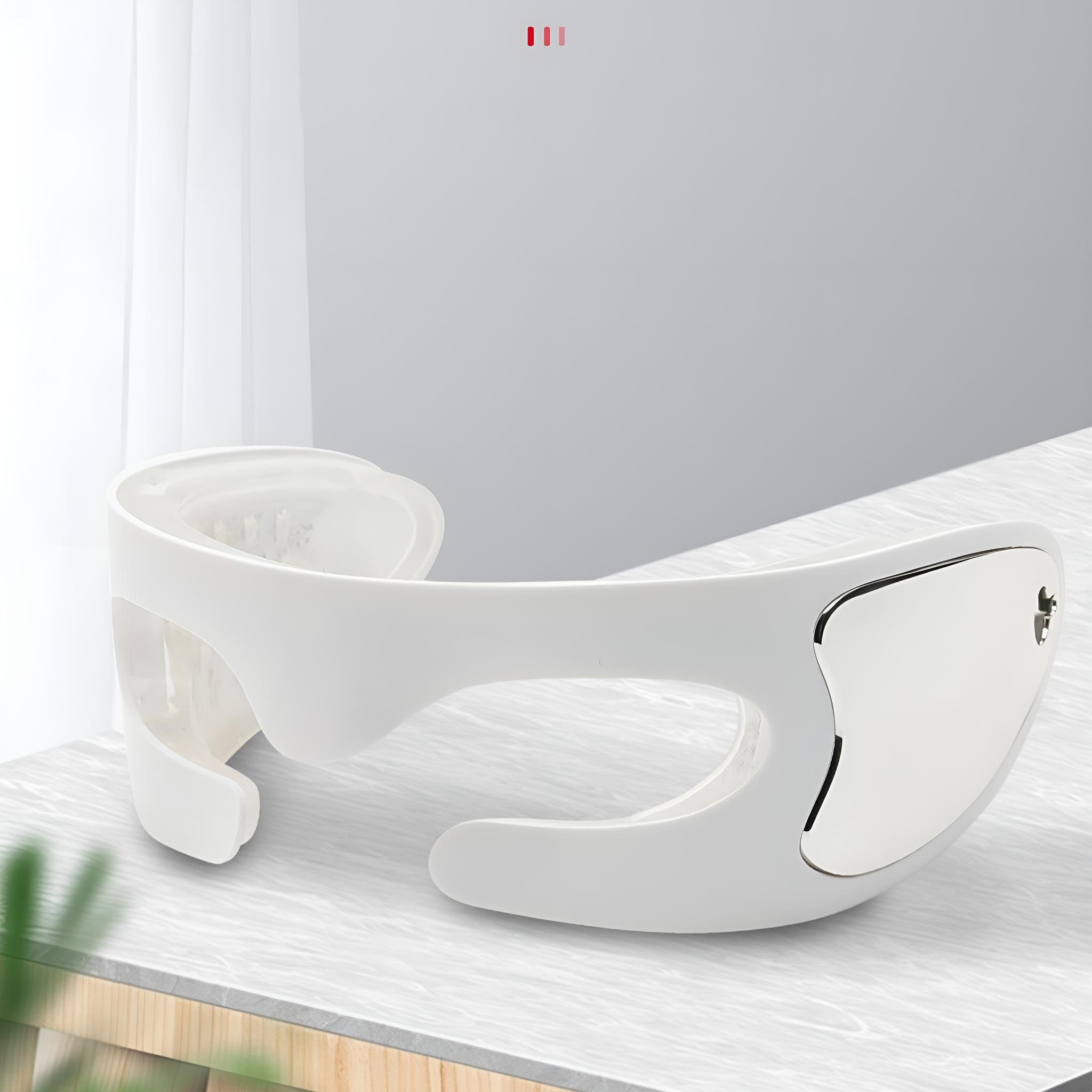 Weißer Nackenmassagegerät, gebogene Form, auf einem Tisch, mit Fenster im Hintergrund.