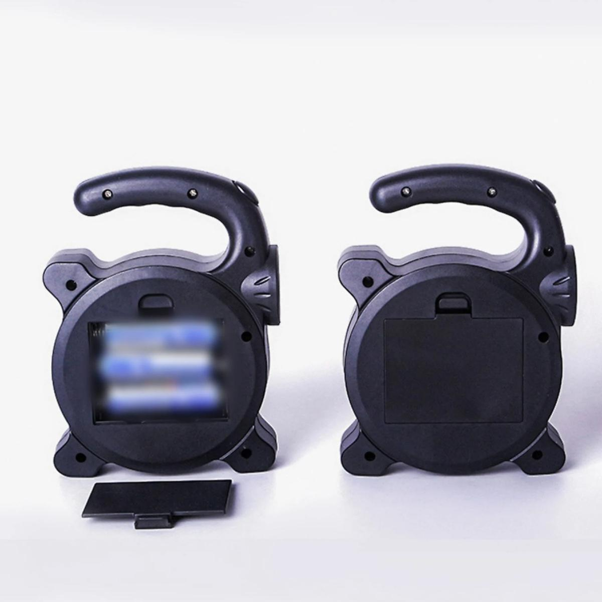 Zwei schwarze tragbare Lampen auf weißem Hintergrund. Eine hat das Batteriefach geöffnet.