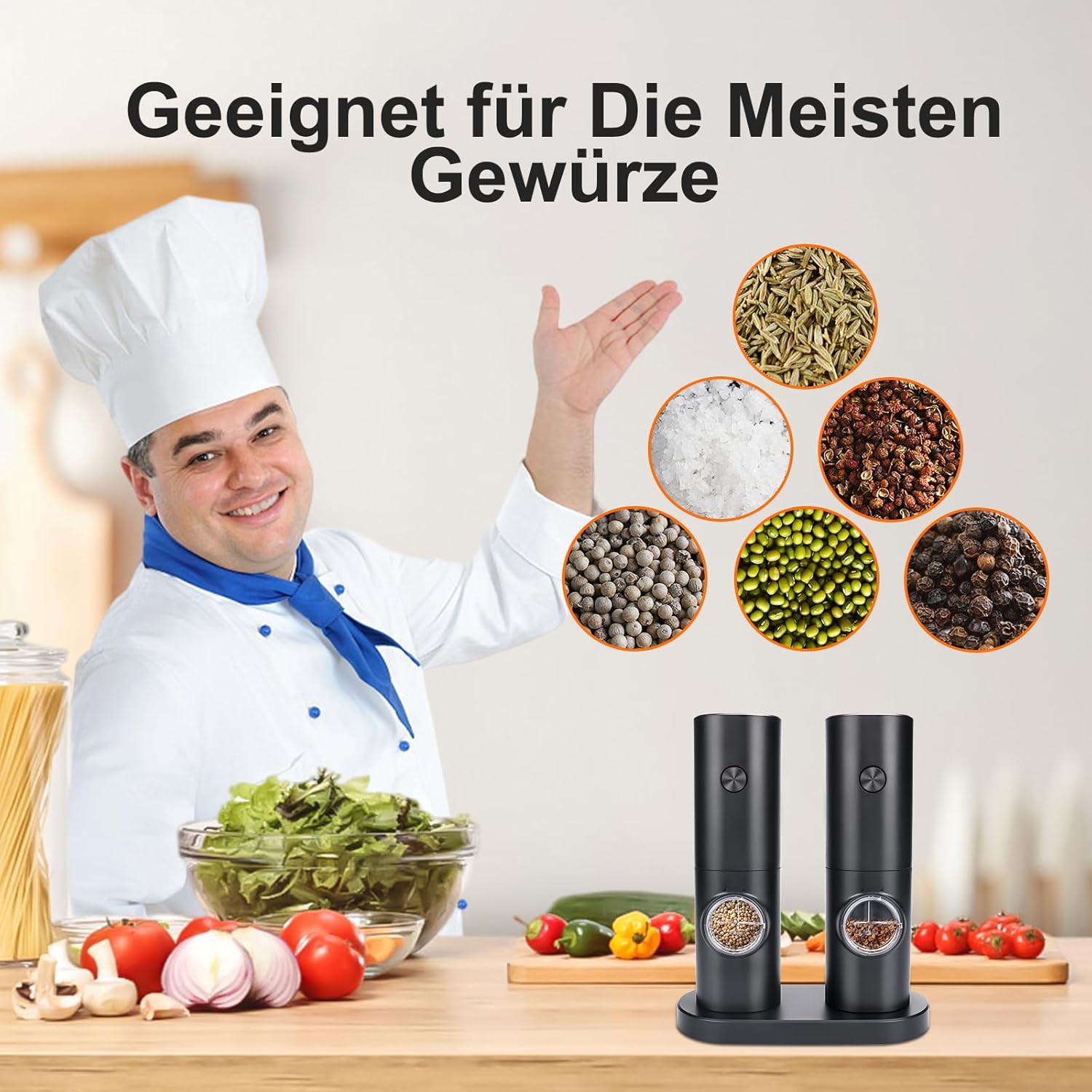 Ein Koch zeigt auf Gewürze auf einem Tisch. Zwei schwarze Pfeffermühlen stehen auf dem Tisch. Gemüse ist im Bild.