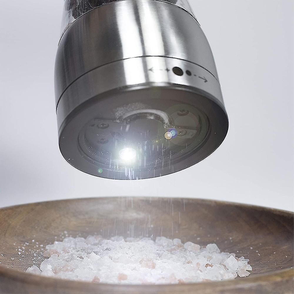 Eine Pfeffermühle, das Licht scheint auf Salz in einer Holzschale.