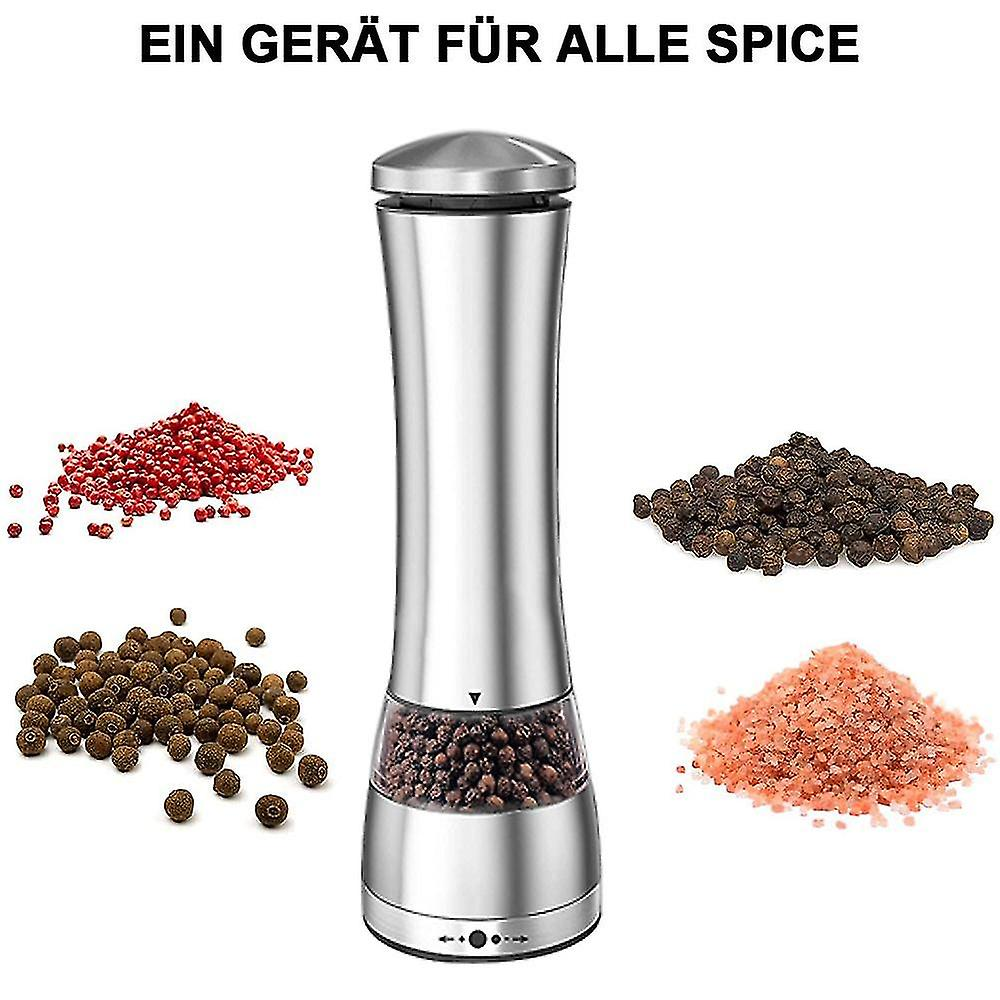 Eine silberne Gewürzmühle neben Haufen verschiedener Gewürze: roter Pfeffer, schwarzer Pfeffer und rosa Salz.