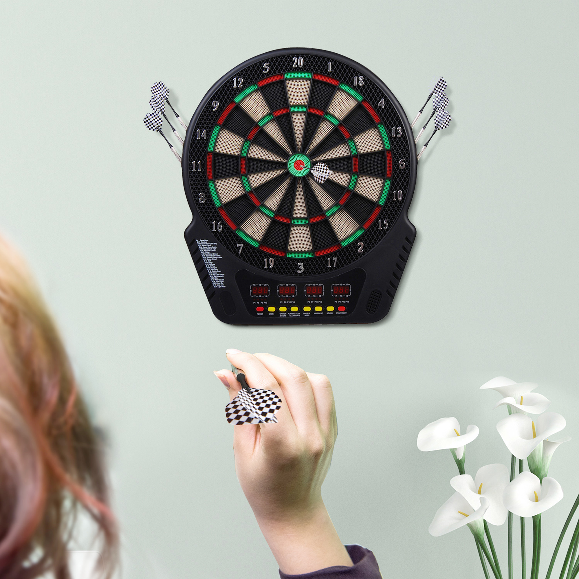 Frau hält Dart, zielt auf Dartscheibe an der Wand, Darts drumherum.