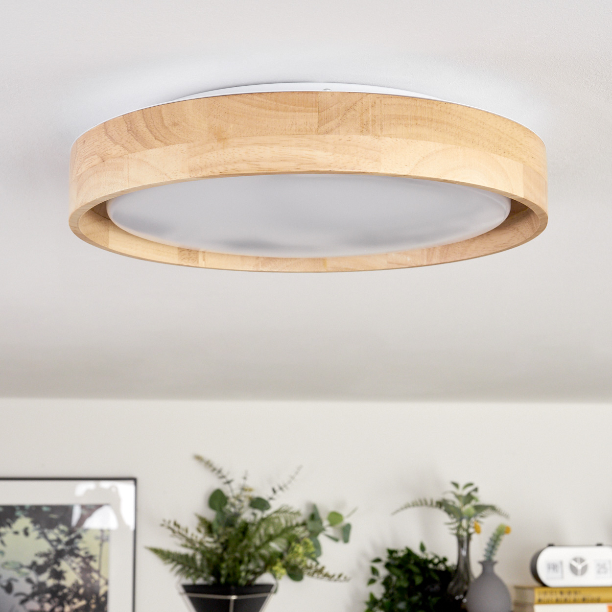 Eine runde Deckenlampe aus Holz ist an einer weißen Decke montiert.